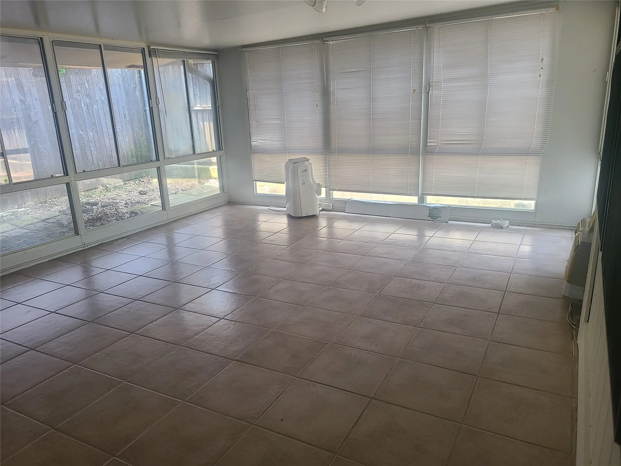 Large sunroom equipped with a window AC.  This space can be a living area, game room or office.