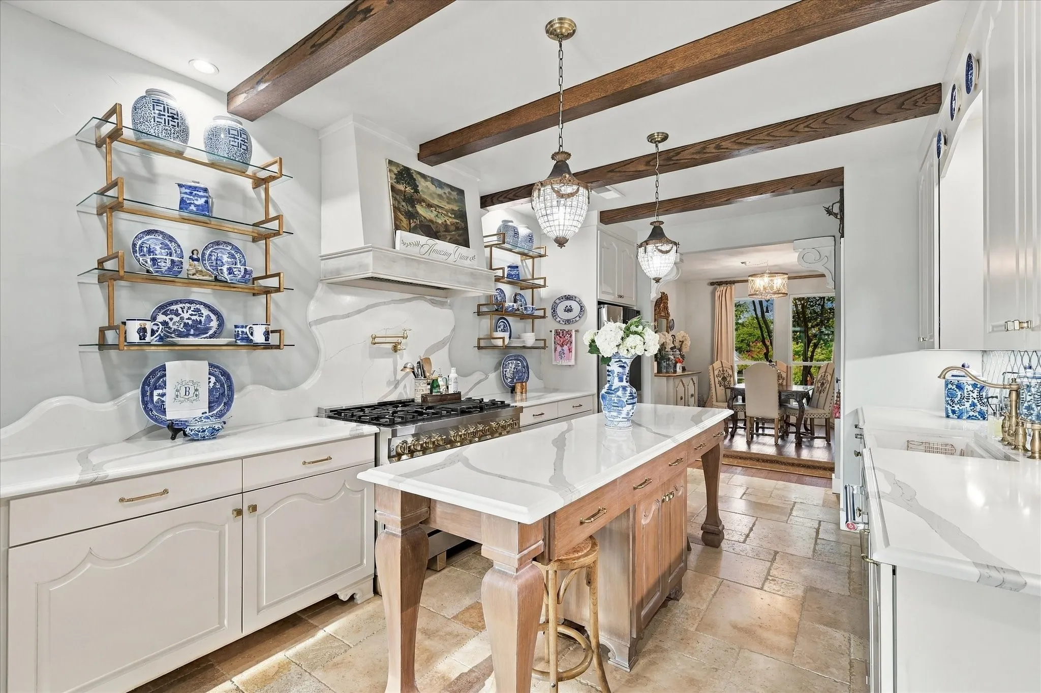 Designer shelving, traventine flooring, wood beams and the custon island is moveable