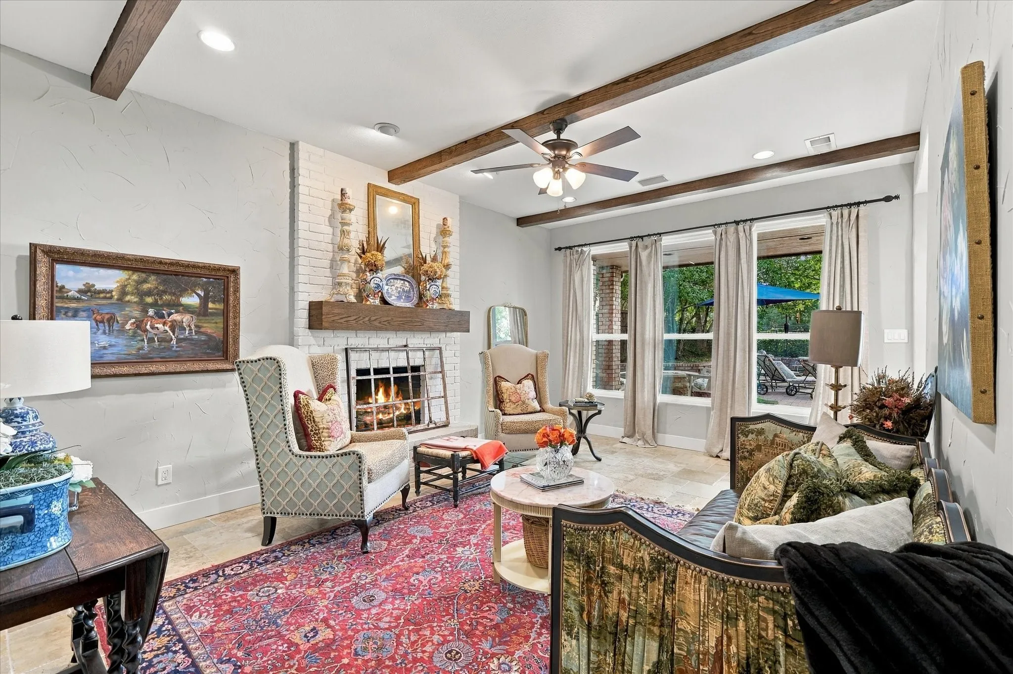 Secondary living area adjacent to kitchen with wood beams, traventine flooring, custom built wood mantel. This room could be modified to accomodate a dining table and chairs for a larger area to entertain.