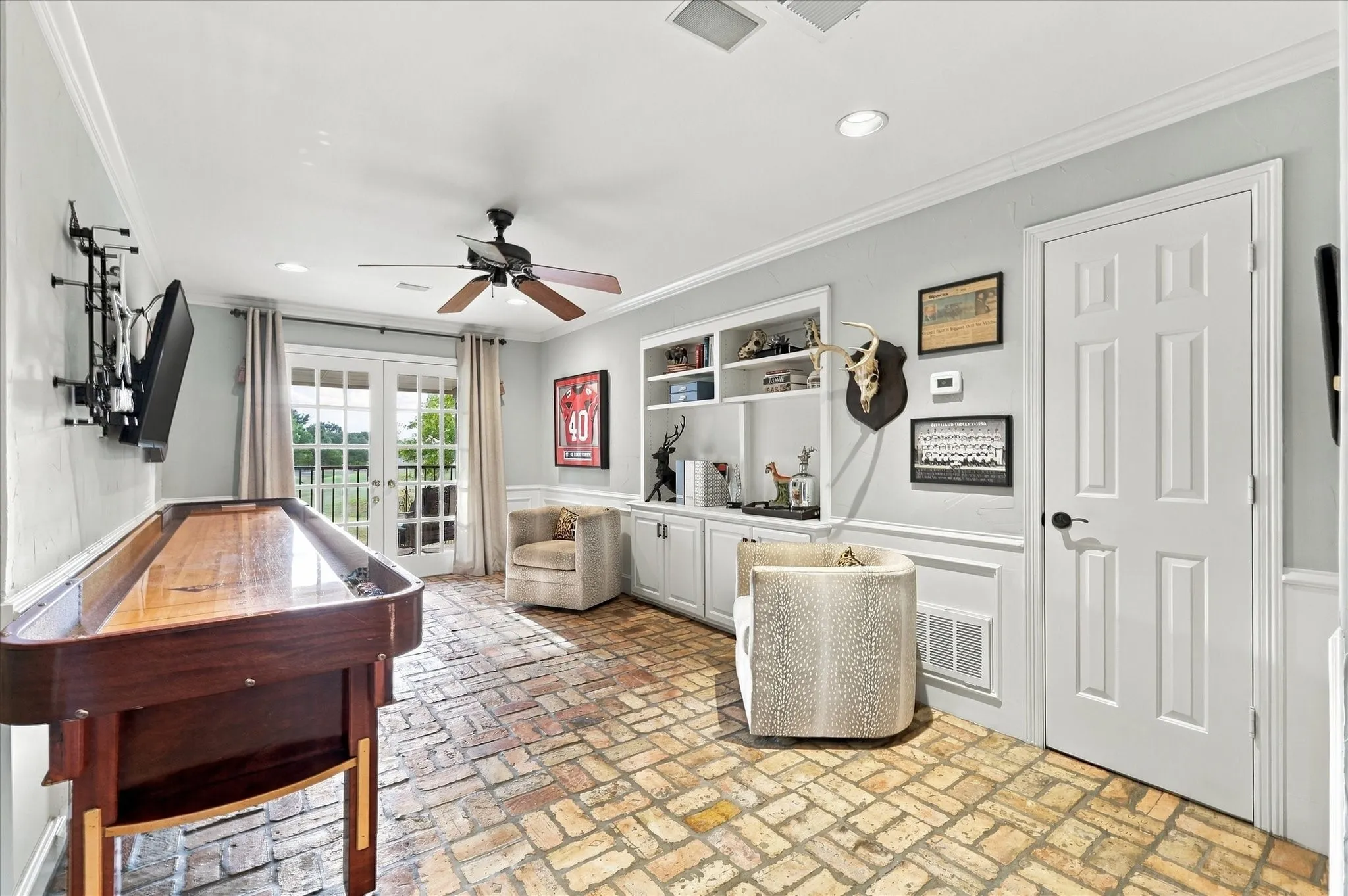 Upstairs living area that current owners have made into a shuffleboard area with sitting area.  This room features double doors to outdoor balcony overlooking pool and golf course.