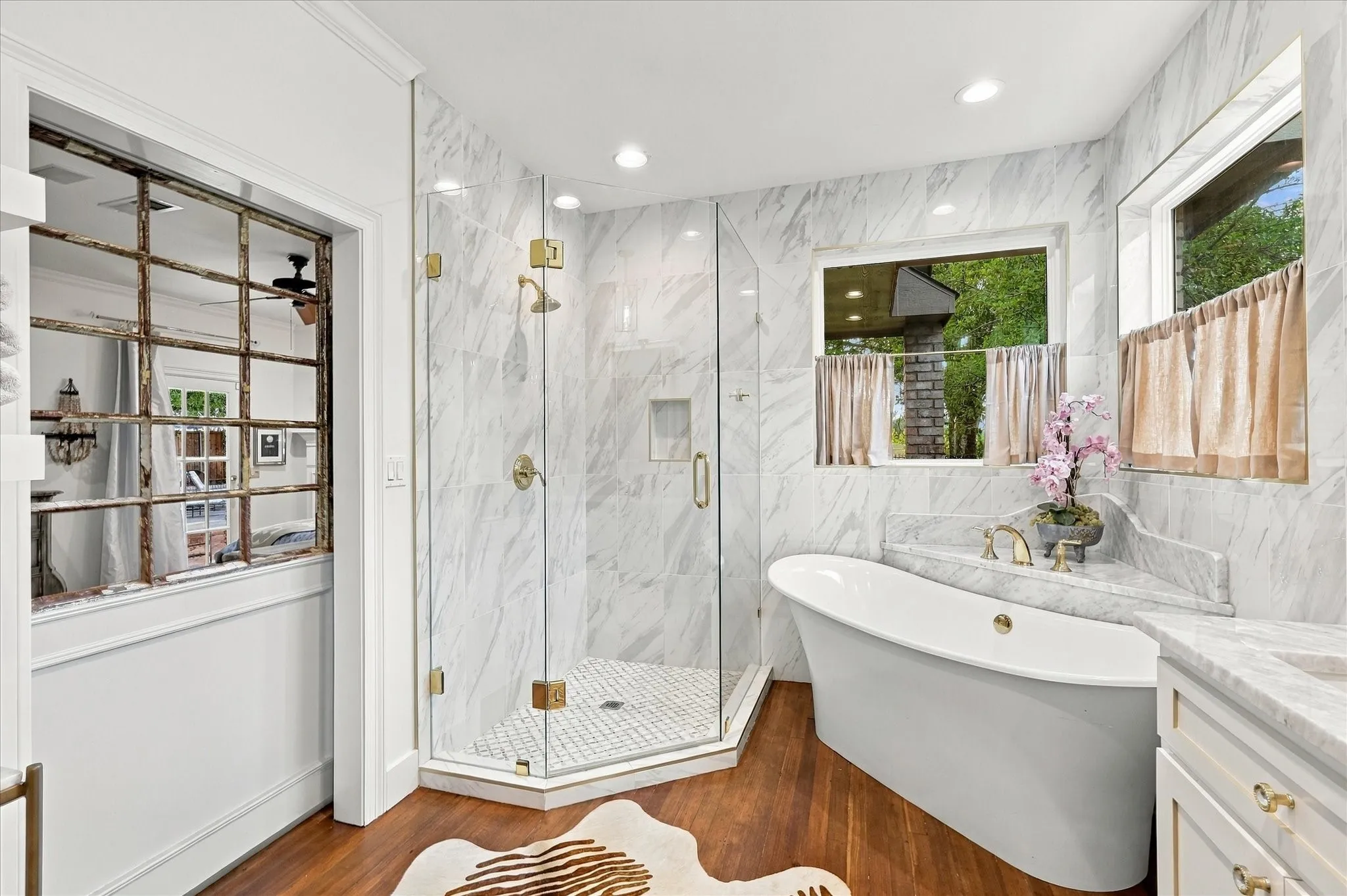 Primary bathroom has been totally remodeled with separate hollywood tub, oversized tiled shower with seamless glass and custom hinges.
