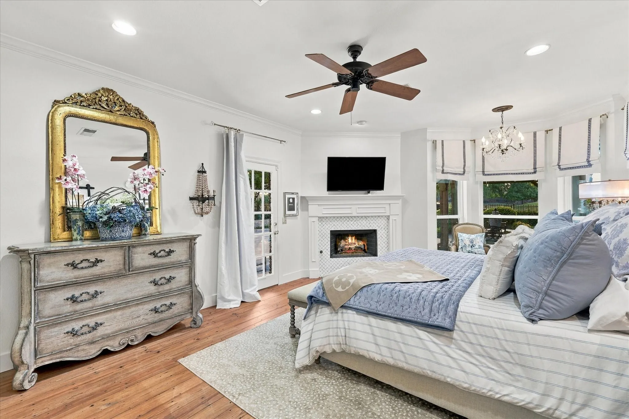 Additional view of primary suite with bright lights, ceiling fan and private exit to outdoor area.