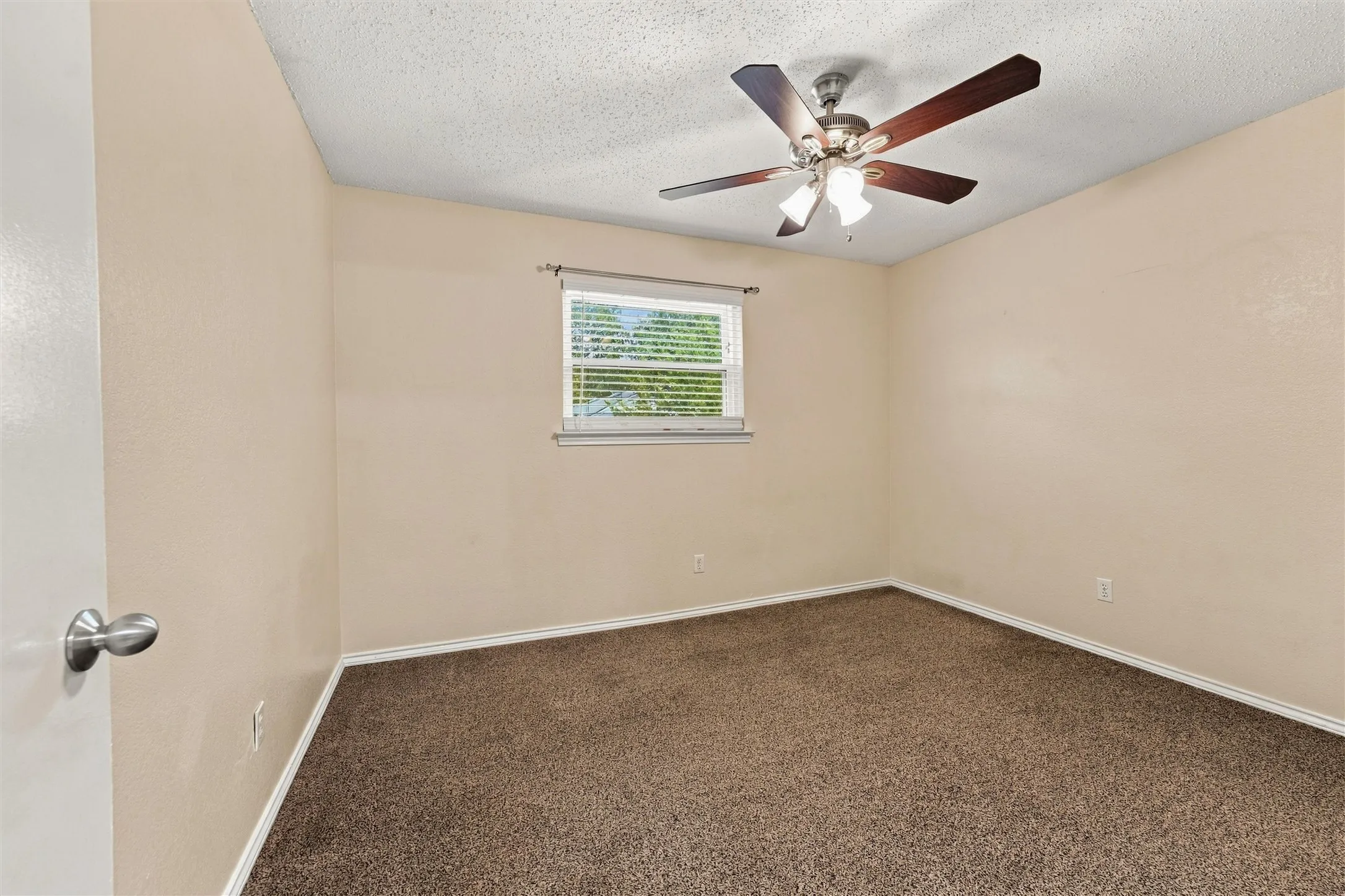 Recessed window with blinds, overhead ceiling fan with lighting, light-toned wall paint, and carpet flooring