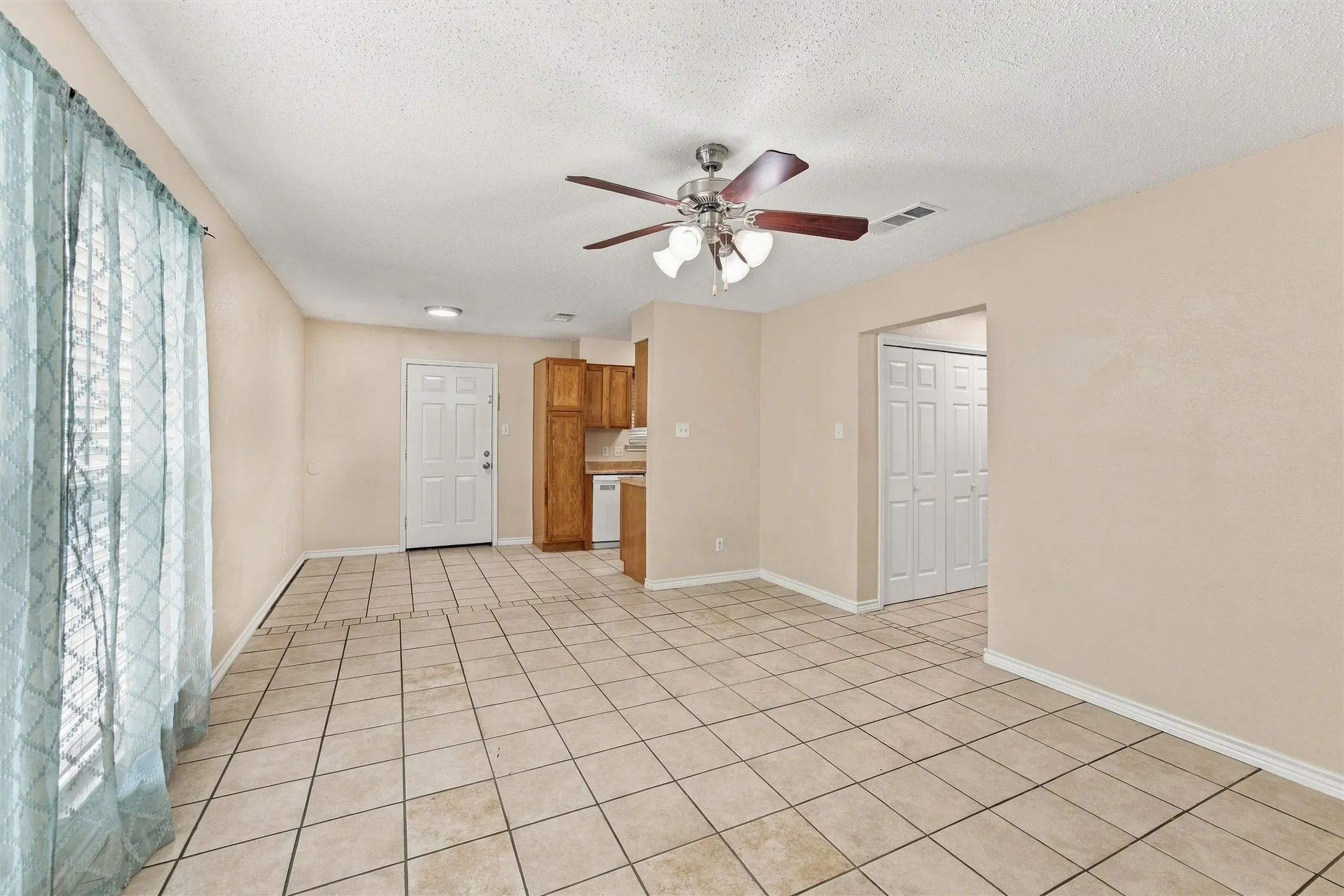 Ceramic tile flooring, ceiling fan with integrated lighting, recessed lighting, wood cabinetry, and a paneled door