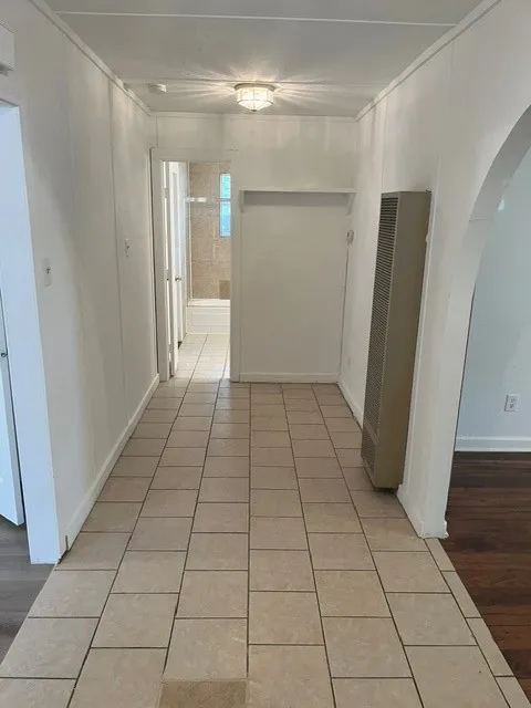 Hallway featuring tiled flooring, a flush-mount ceiling light, and a wall heater