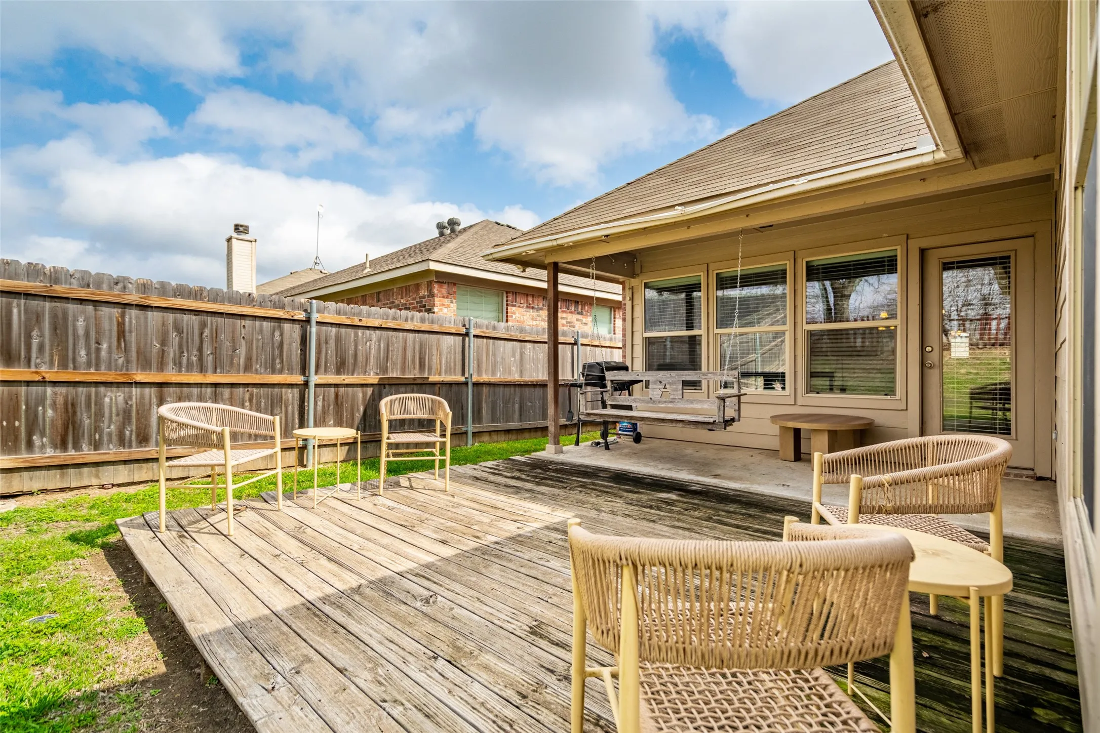 Expansive wood-plank deck with a covered patio area and a privacy fence