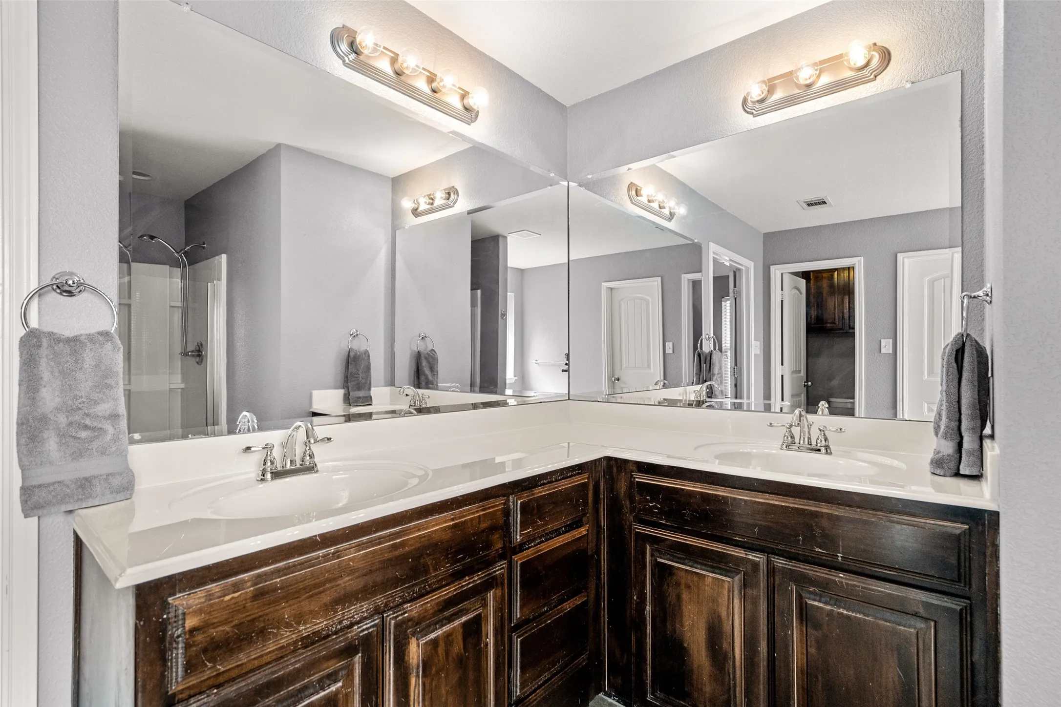 Double vanity with dark wood-finish cabinetry and integrated sinks