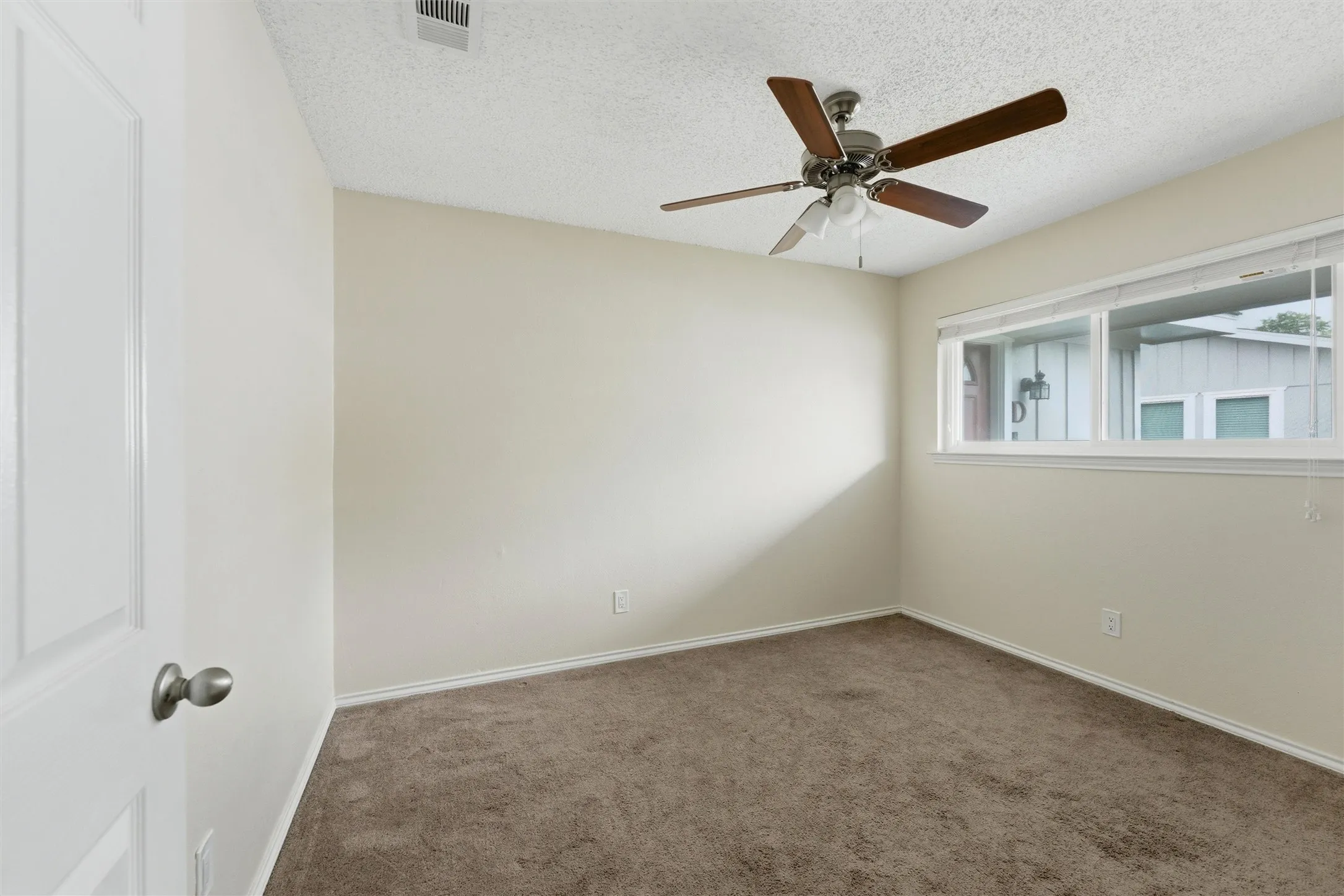 Recessed window, ceiling fan with light kit, textured ceiling, neutral wall color, and wall-to-wall carpeting