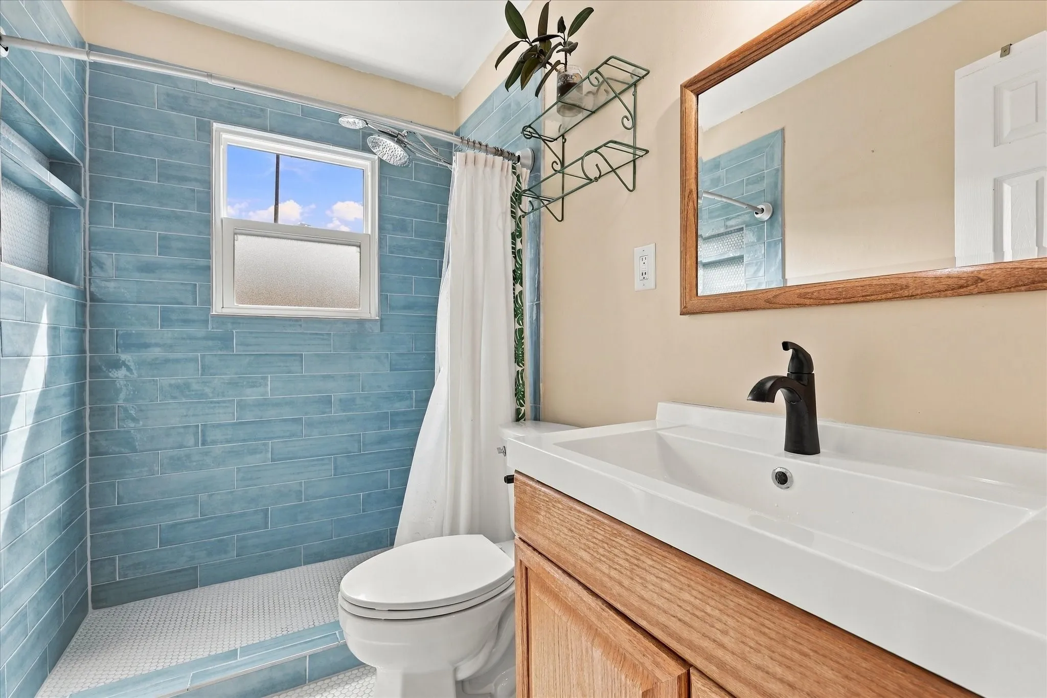 Remodeled bathroom with walk-in shower, tile flooring and walls