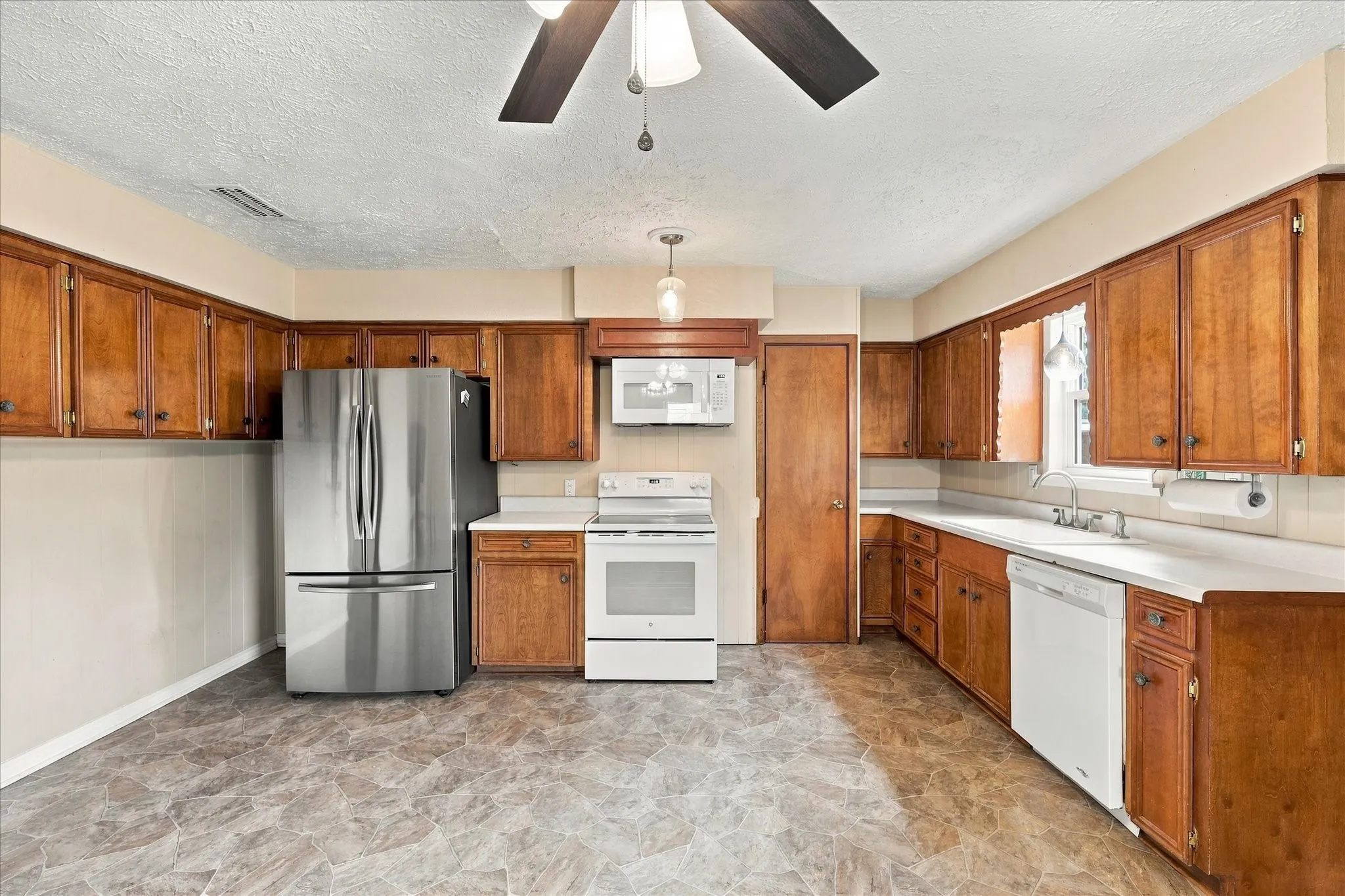 Kitchen features new refrigerator, electric range, microwave, and dishwasher