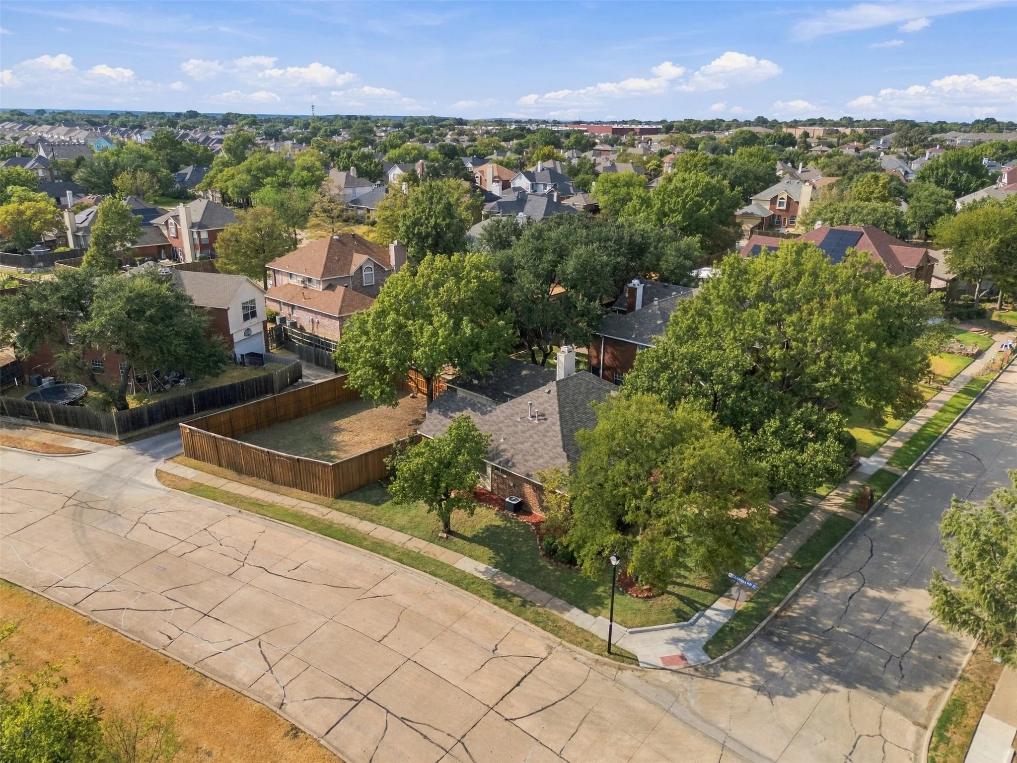 Corner lot with mature trees, fenced backyard, and established landscaping