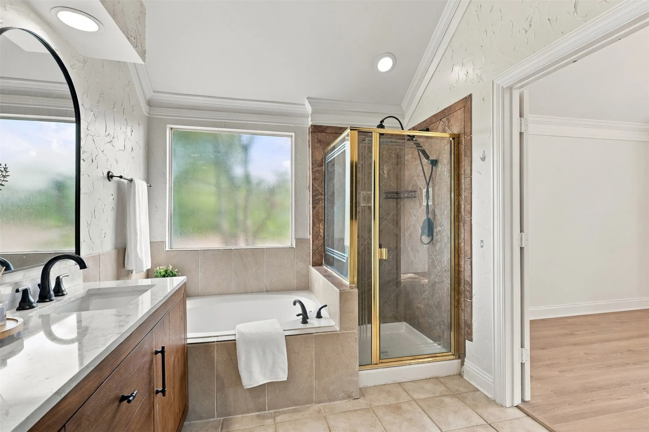Wood-finish vanity with a white countertop and black fixtures