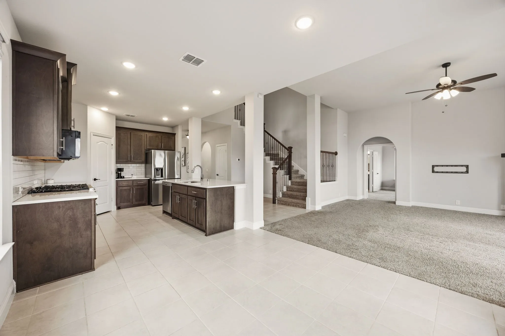 Open-concept living area with tile flooring, recessed lighting, and a ceiling fan