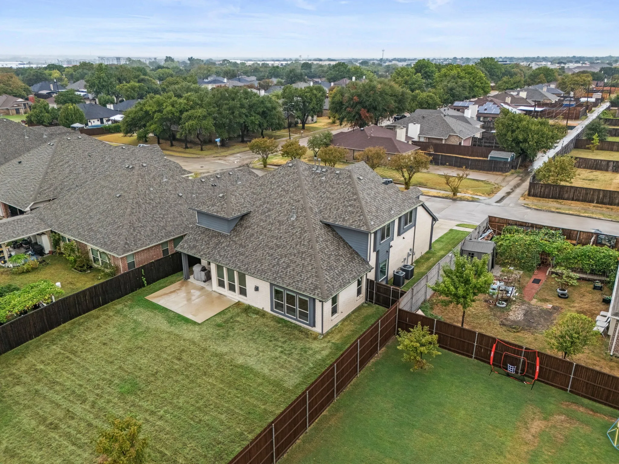 Expansive backyard featuring a manicured lawn, a concrete patio, and a privacy fence