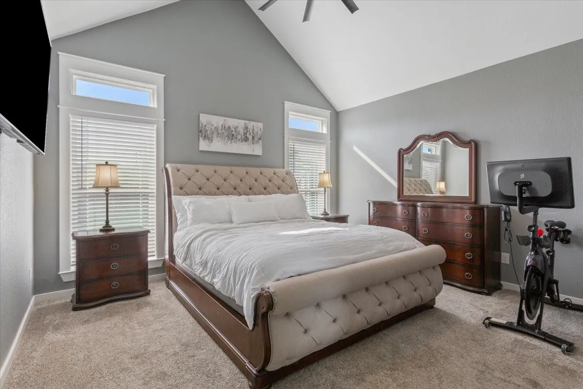 Vaulted ceiling, carpeted flooring, and window blinds