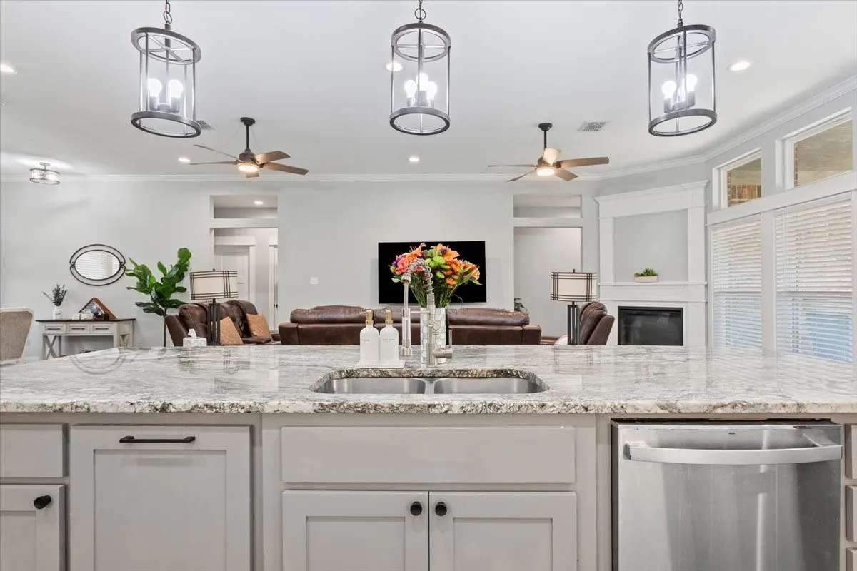 Spacious kitchen island featuring a dual basin sink and stone-finish countertop