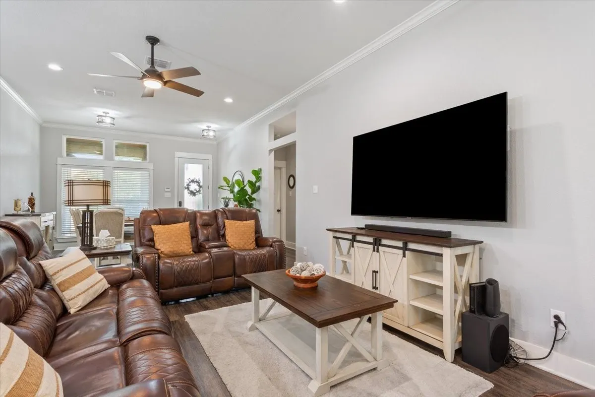 Recessed lighting, crown molding, wood-finish flooring, and a ceiling fan with integrated lighting