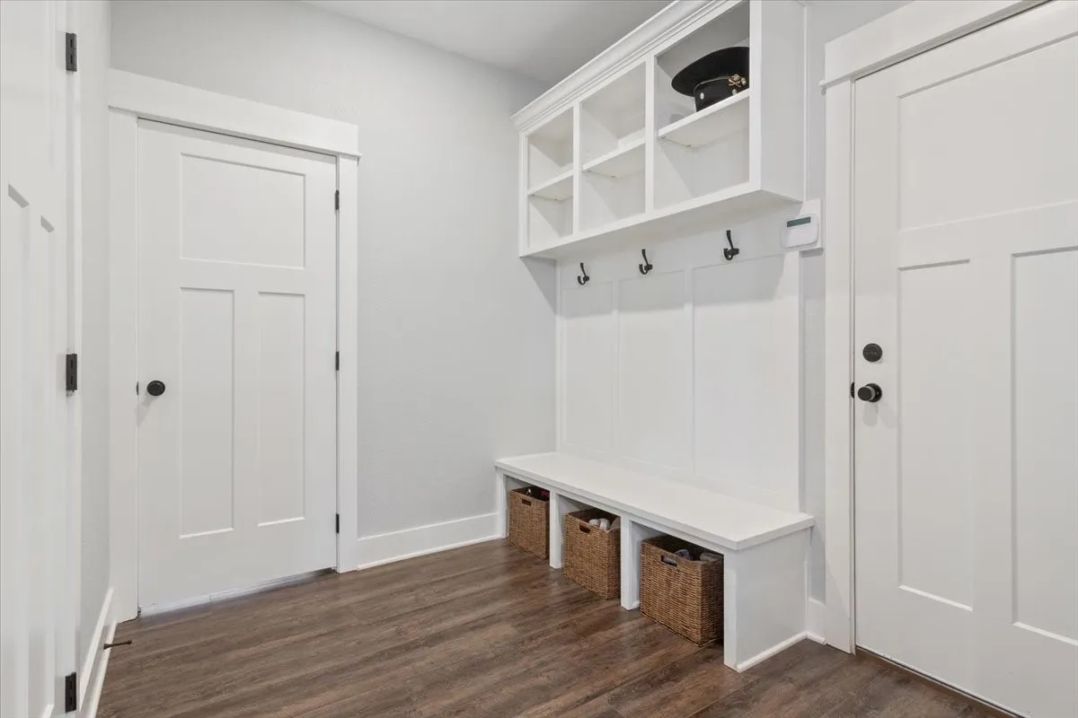 Built-in storage bench with cubbies, upper shelving, and coat hooks