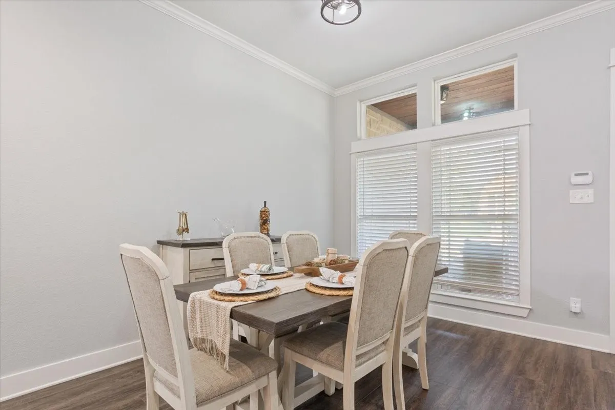 Wood-finish flooring, crown molding, and white trim accents