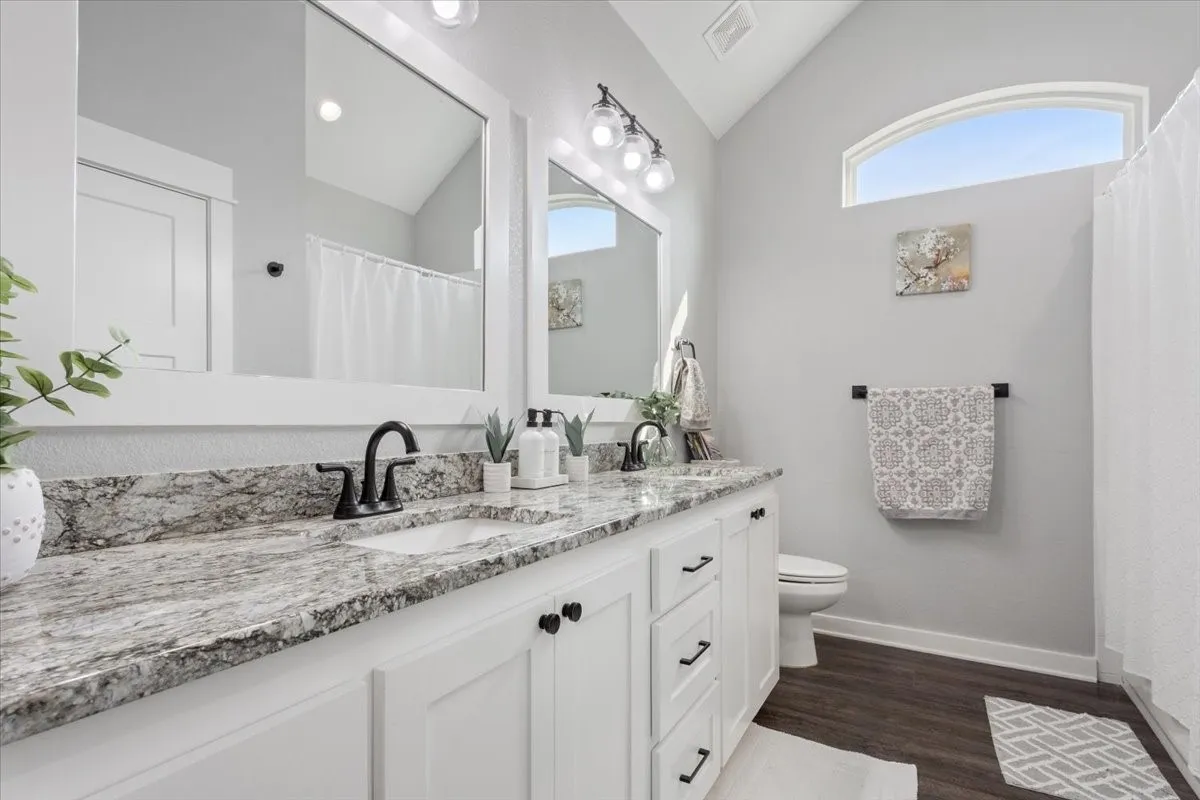 Dual vanity with integrated sinks, granite-style countertop, and matte black fixtures