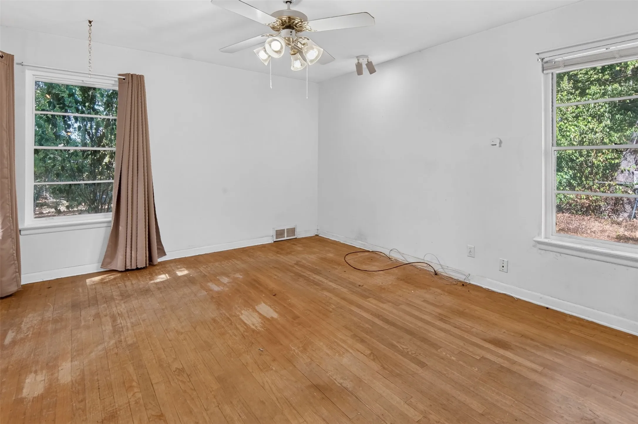 Hardwood flooring throughout, with multiple windows providing natural illumination
