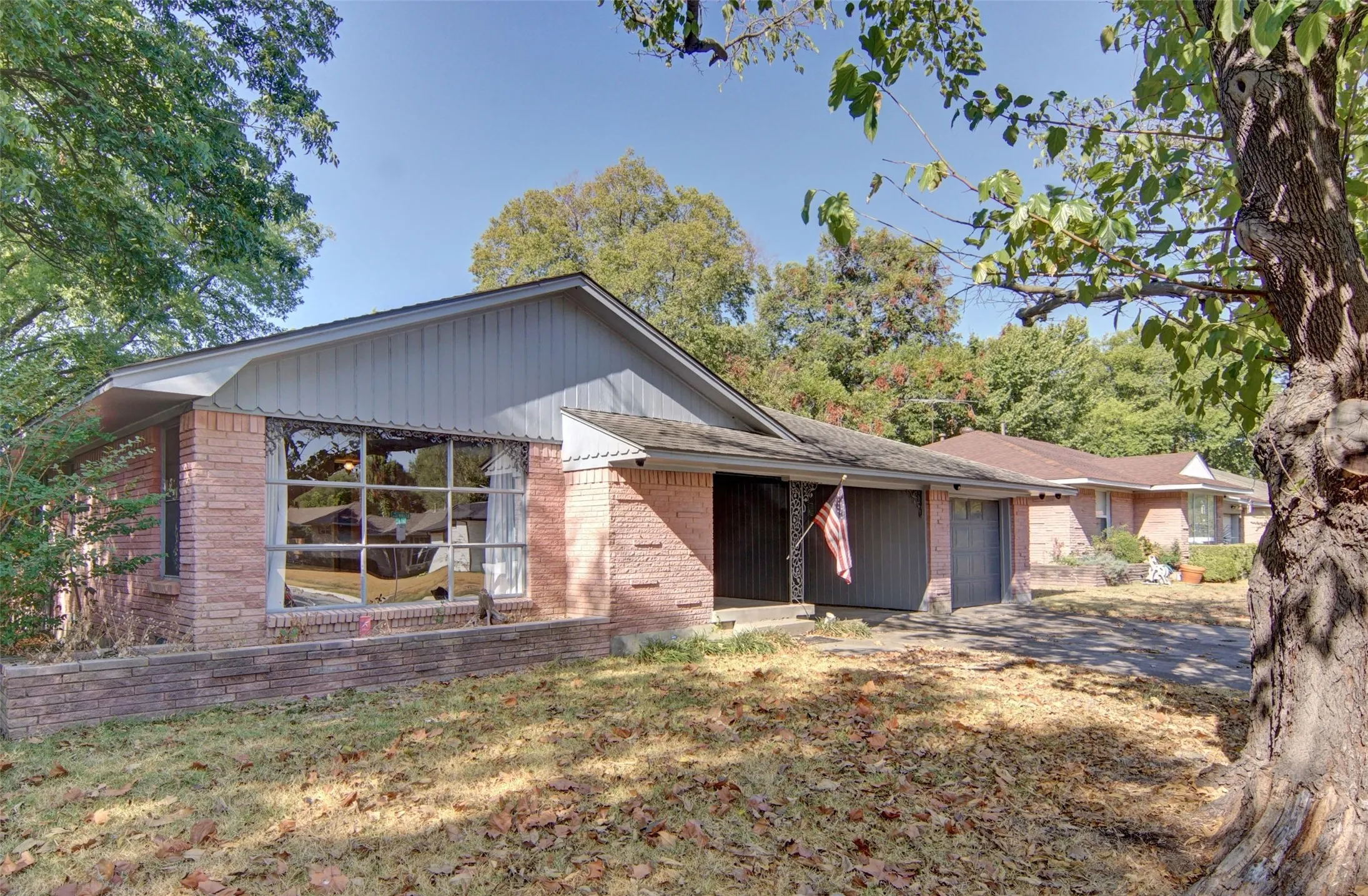 Brick exterior with two garage doors and a prominent front window