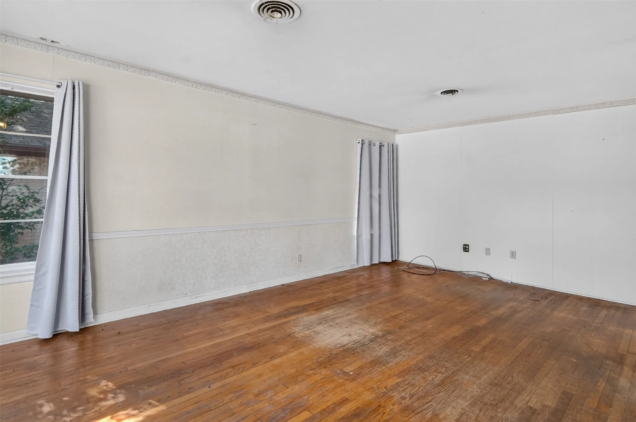 Hardwood flooring, crown molding, chair rail molding, and a window with trim