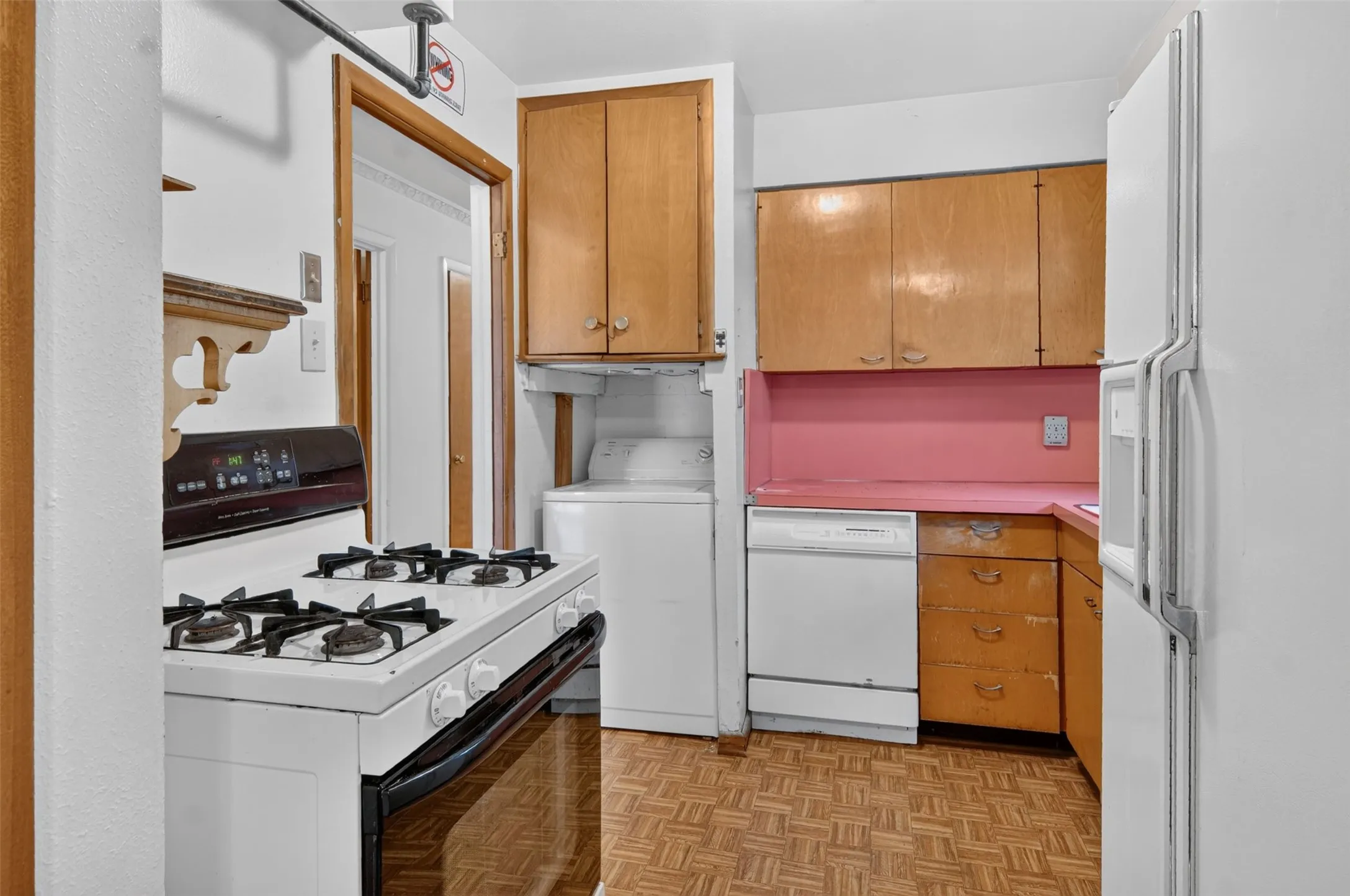 Kitchen featuring wood-finish cabinetry, white stove, white refrigerator, and wood-finish flooring