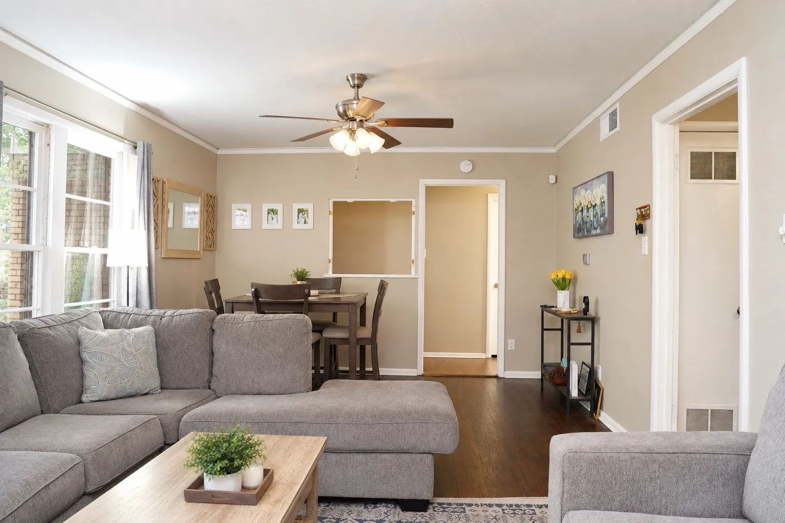 Wood-finish flooring, ceiling fan with integrated lighting, white trim, and neutral wall tones