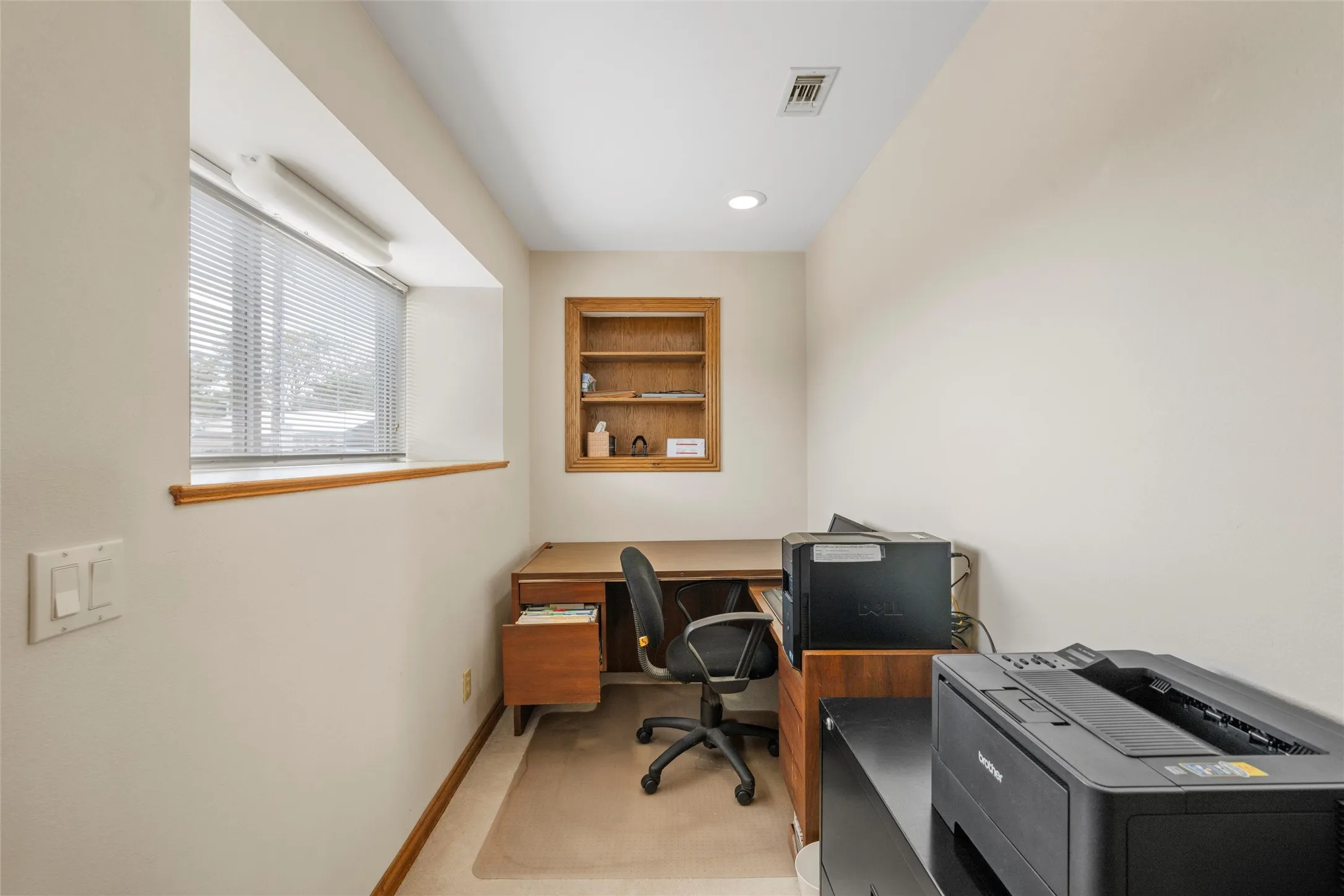 Recessed lighting, wood-finish window trim, built-in shelving, and light-toned walls