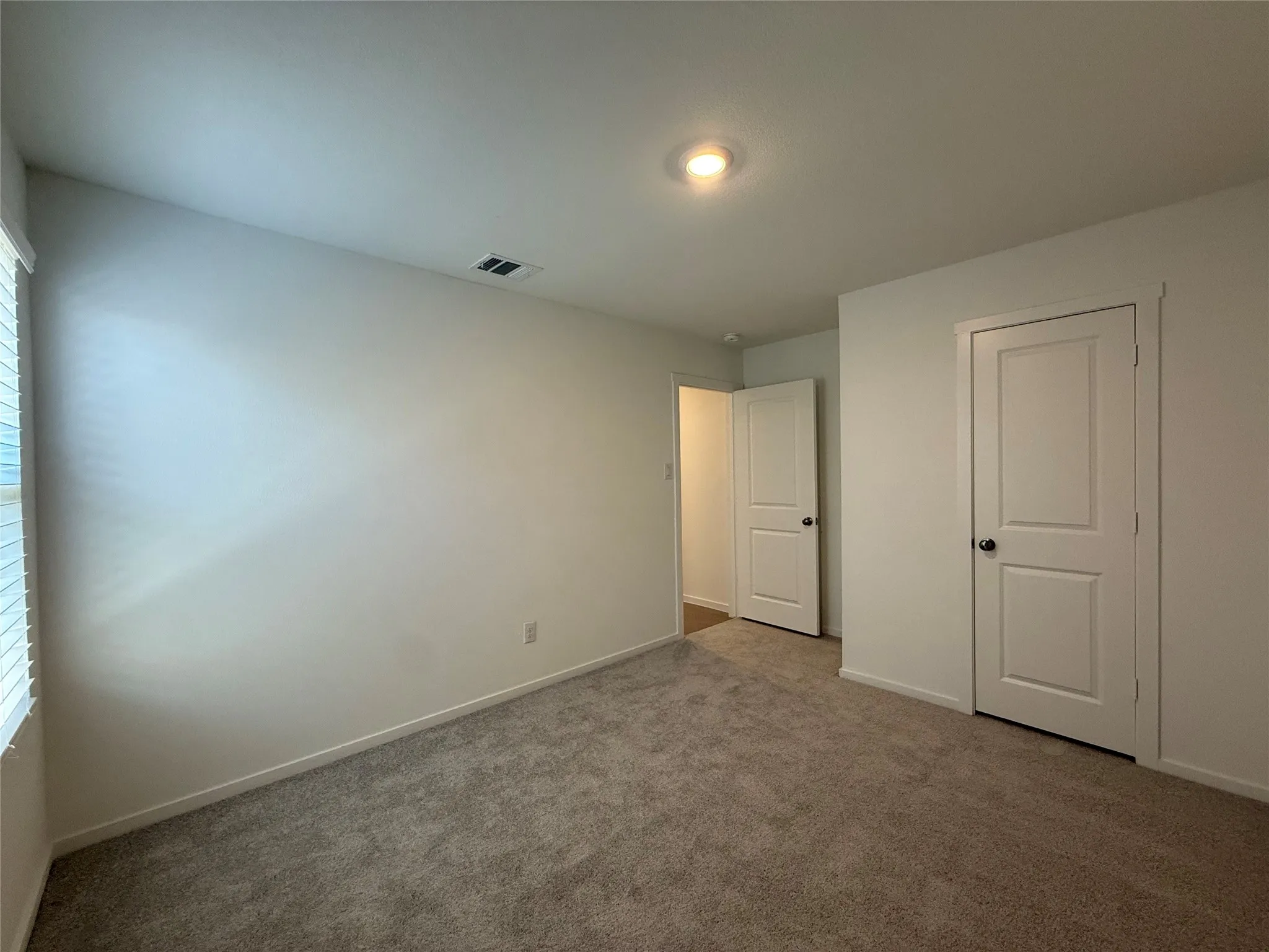 Plush carpeting, recessed ceiling lighting, and crisp white trim