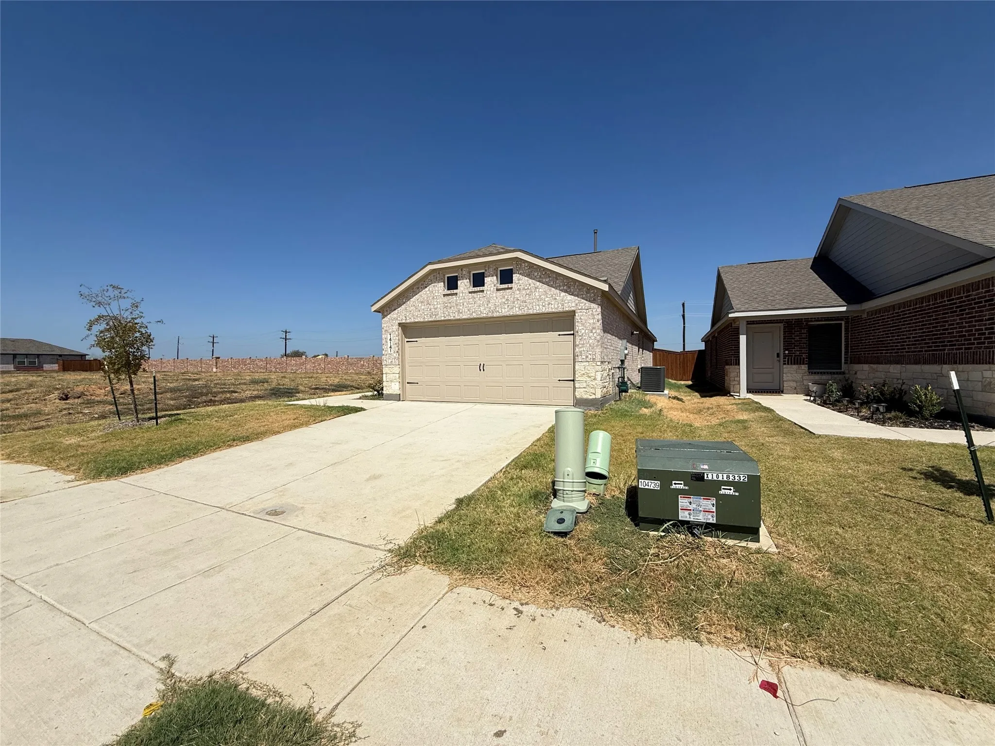 Two single-story homes featuring brick and stone exteriors, asphalt shingle roofs, and concrete driveways