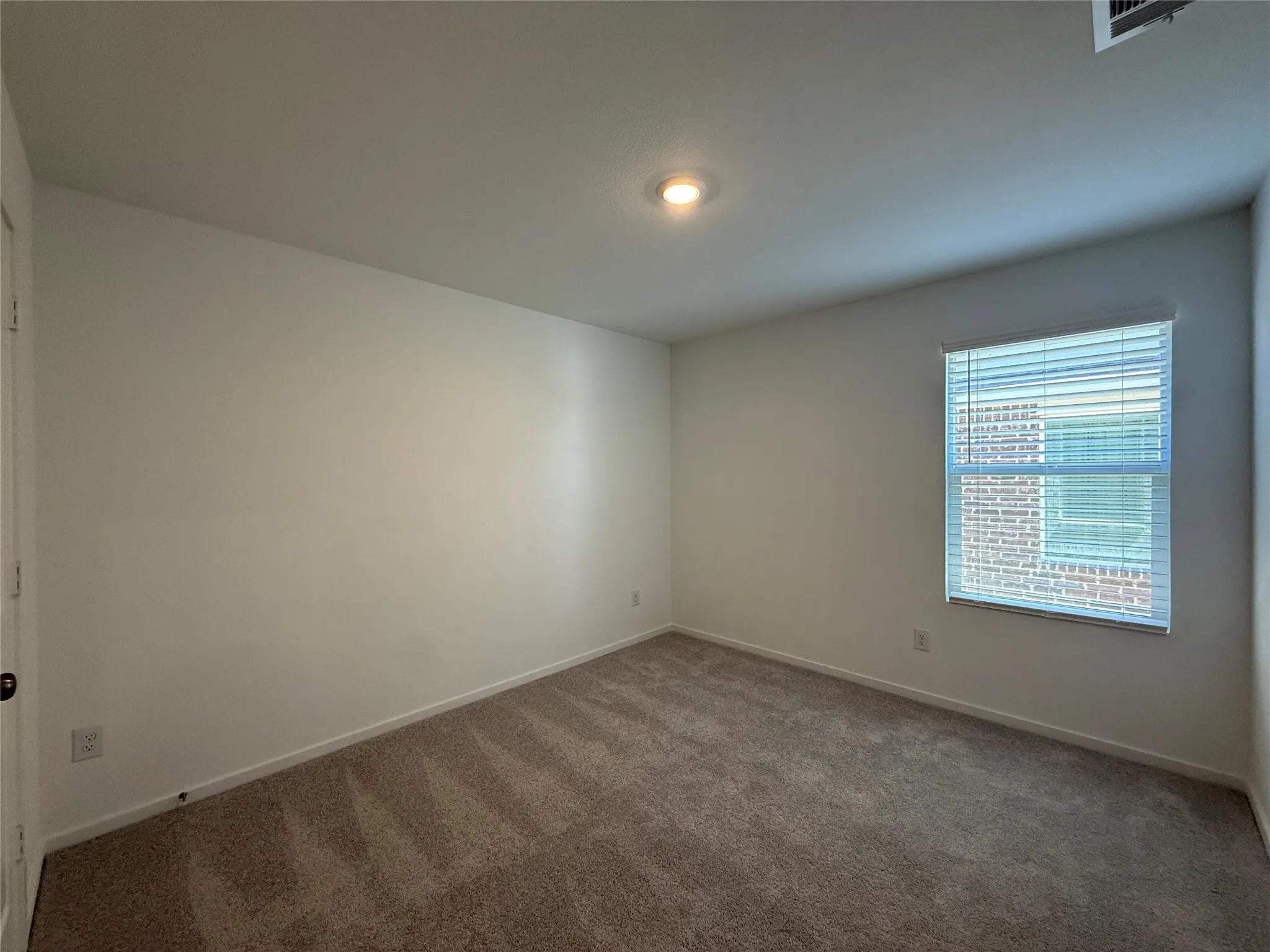 Recessed ceiling lighting, textured wall finish, window with horizontal blinds, neutral tone carpet flooring, white trim