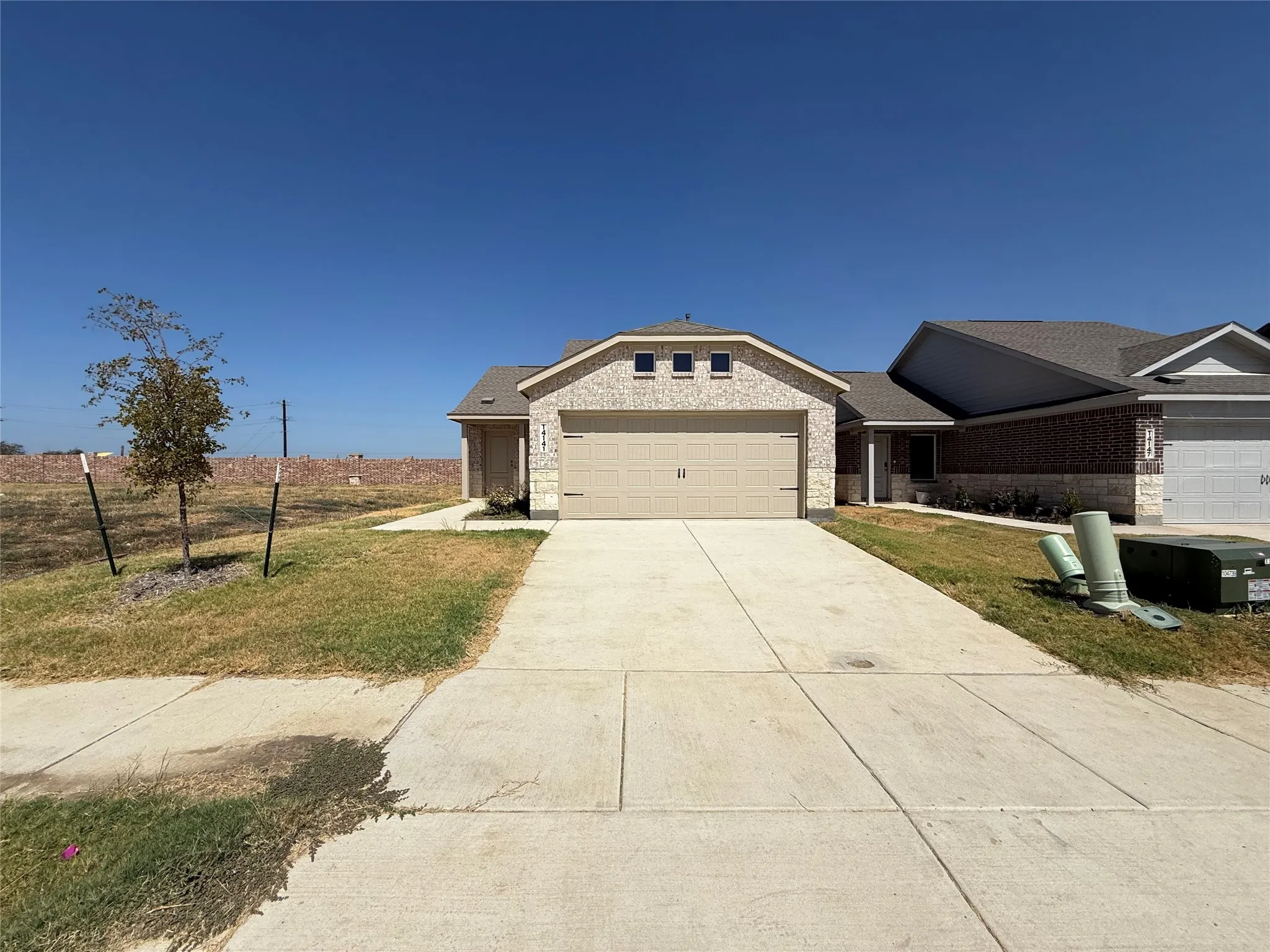 Single-story exterior with a brick facade and attached two-car garage