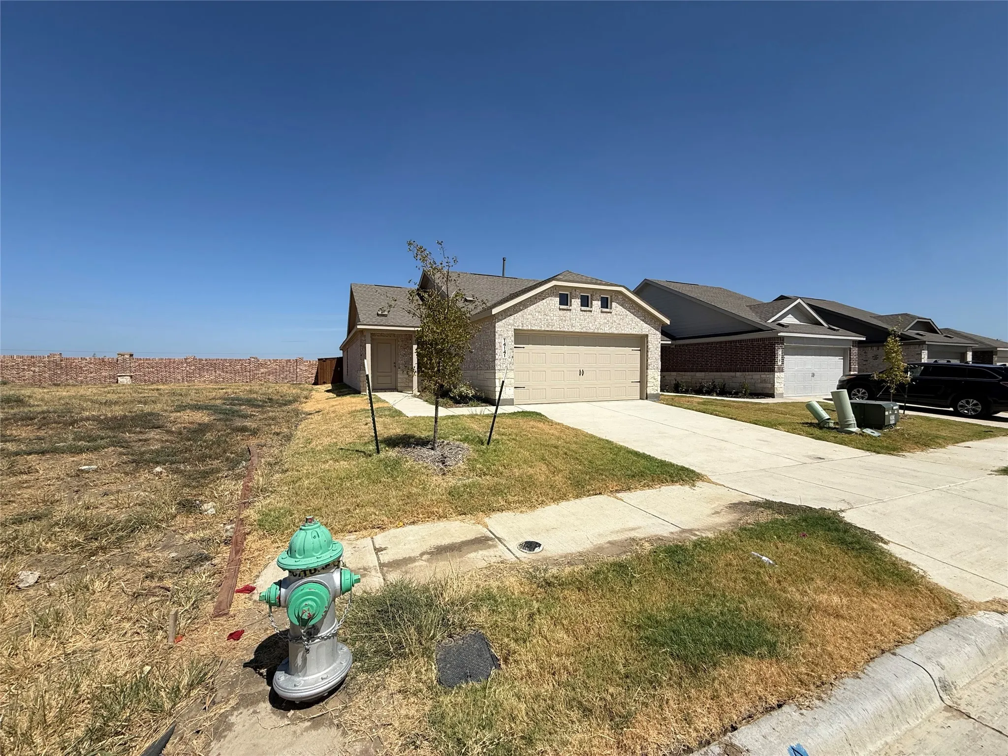Brick veneer exterior with an attached two-car garage, concrete driveway, and a front walkway