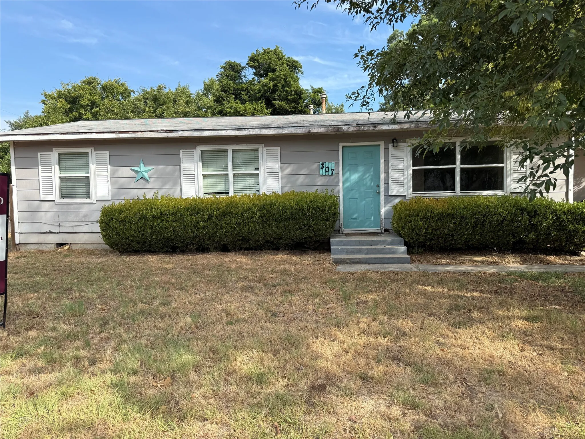 Light gray siding exterior with white window shutters