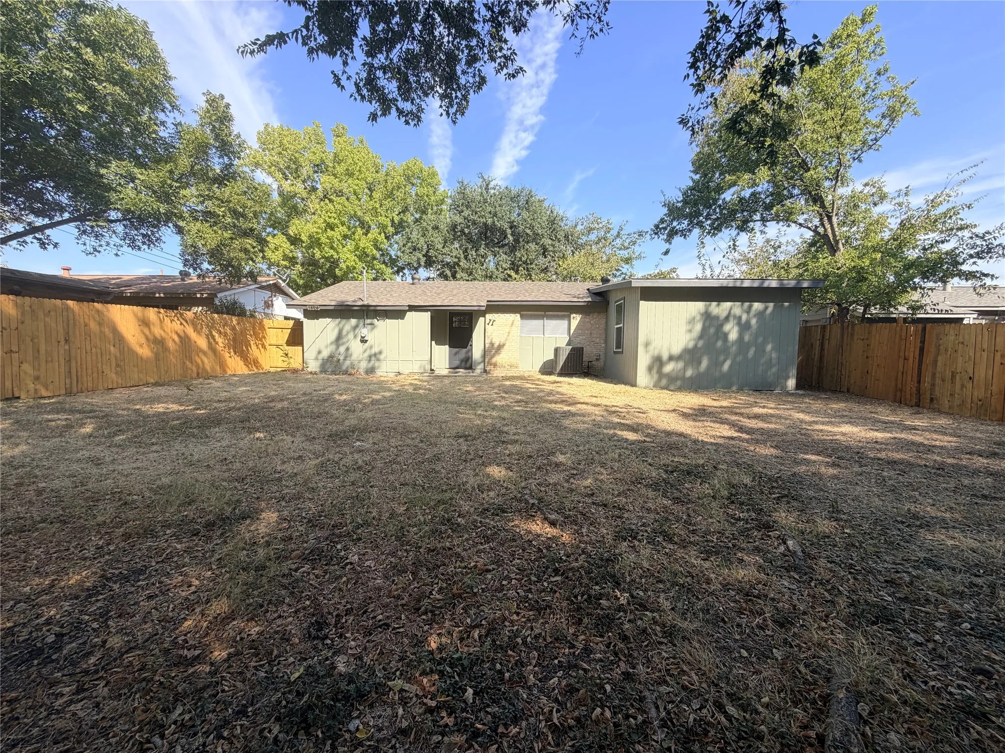 Expansive backyard with wood fencing and mature trees