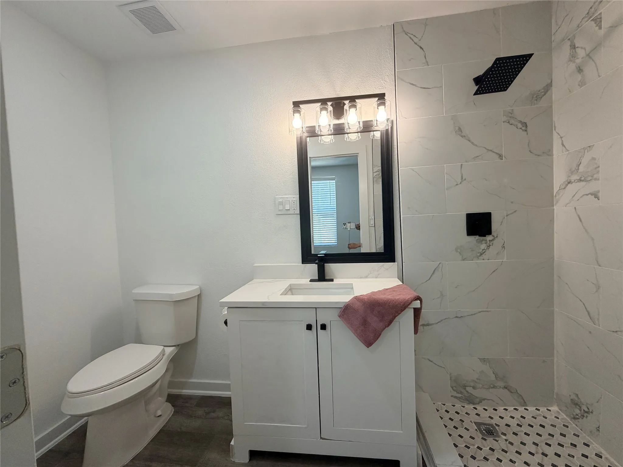 Vanity with white shaker cabinetry, white countertop, and black faucet
