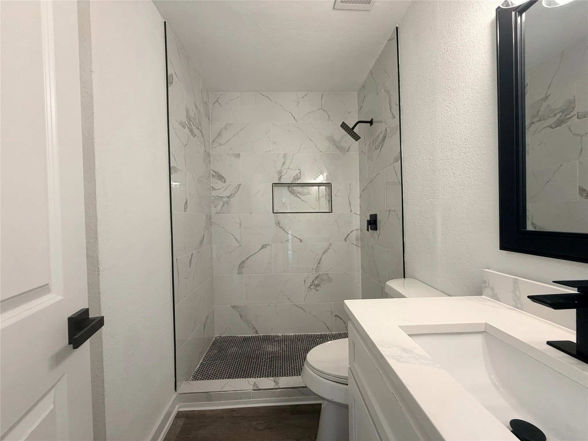 Walk-in shower with full-height tile surround and recessed niche