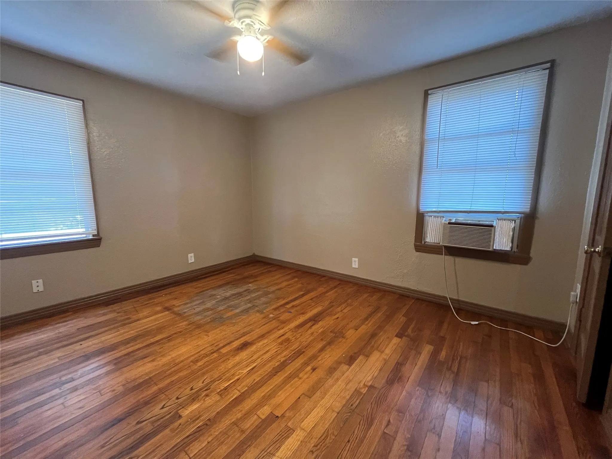 Unfurnished room with ceiling fan, hardwood / wood-style floors, and cooling unit