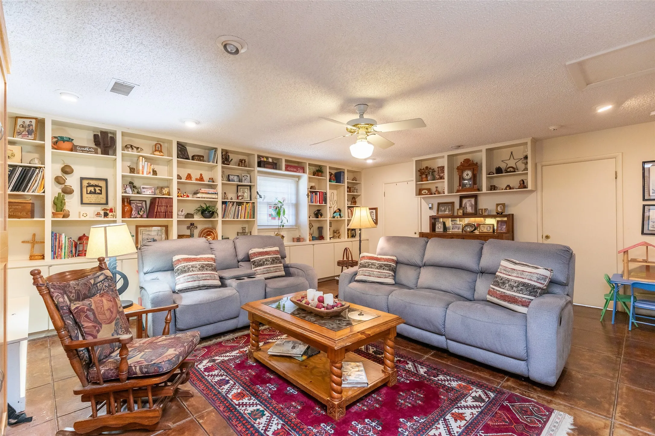 Extensive built-in shelving, ceiling fan light fixture, recessed lighting, and tile flooring