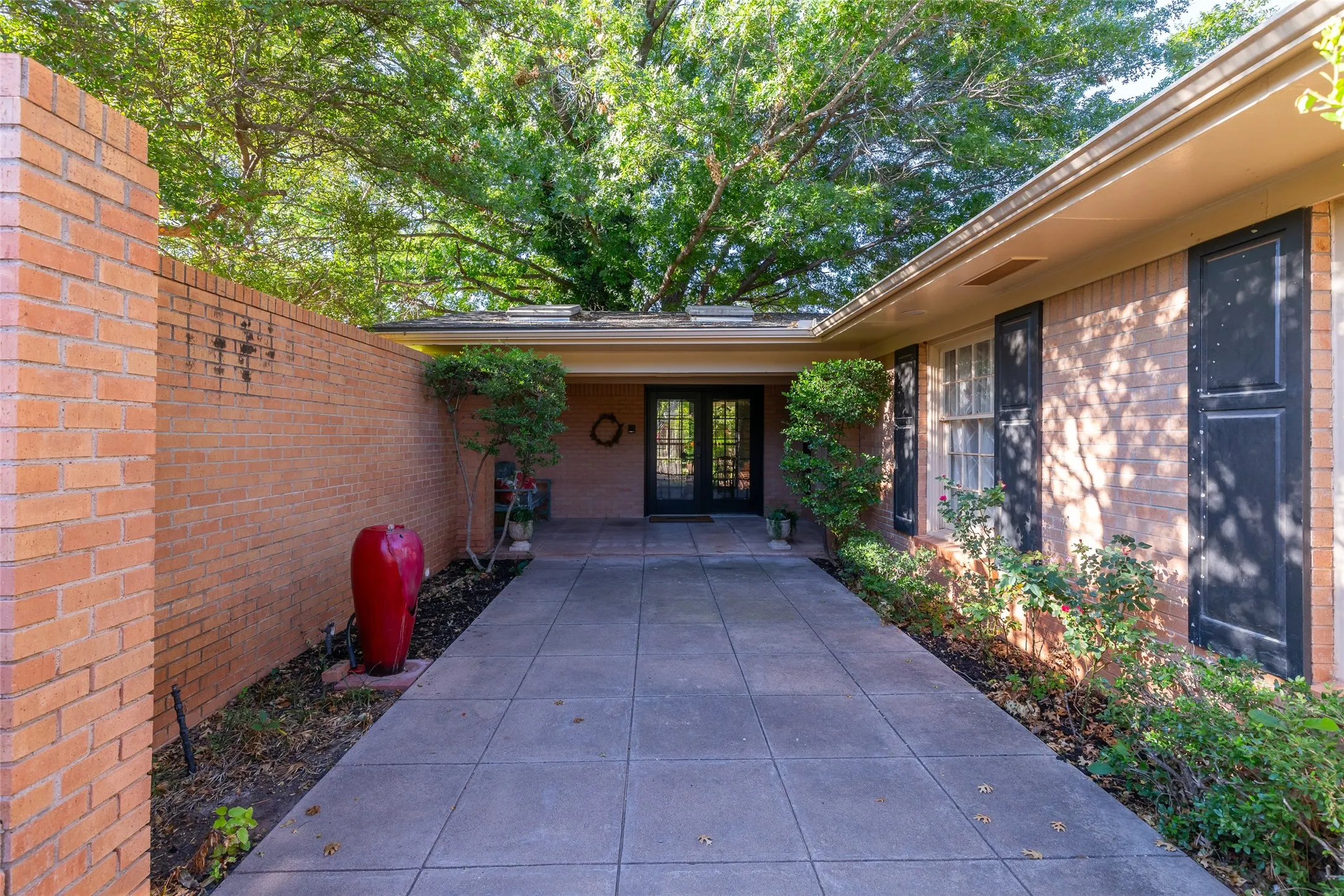 Brick exterior with black shutters and a covered entry