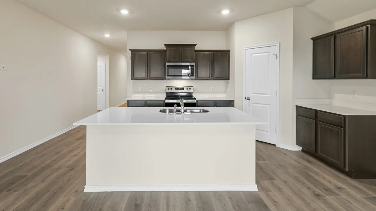 Kitchen featuring a center island, dark wood-finish cabinetry, white countertops, built-in stainless steel appliances, and wood-finish flooring