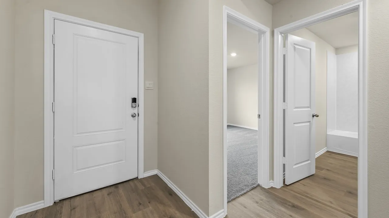 Wood-finish flooring throughout, with a white paneled door and light-toned walls