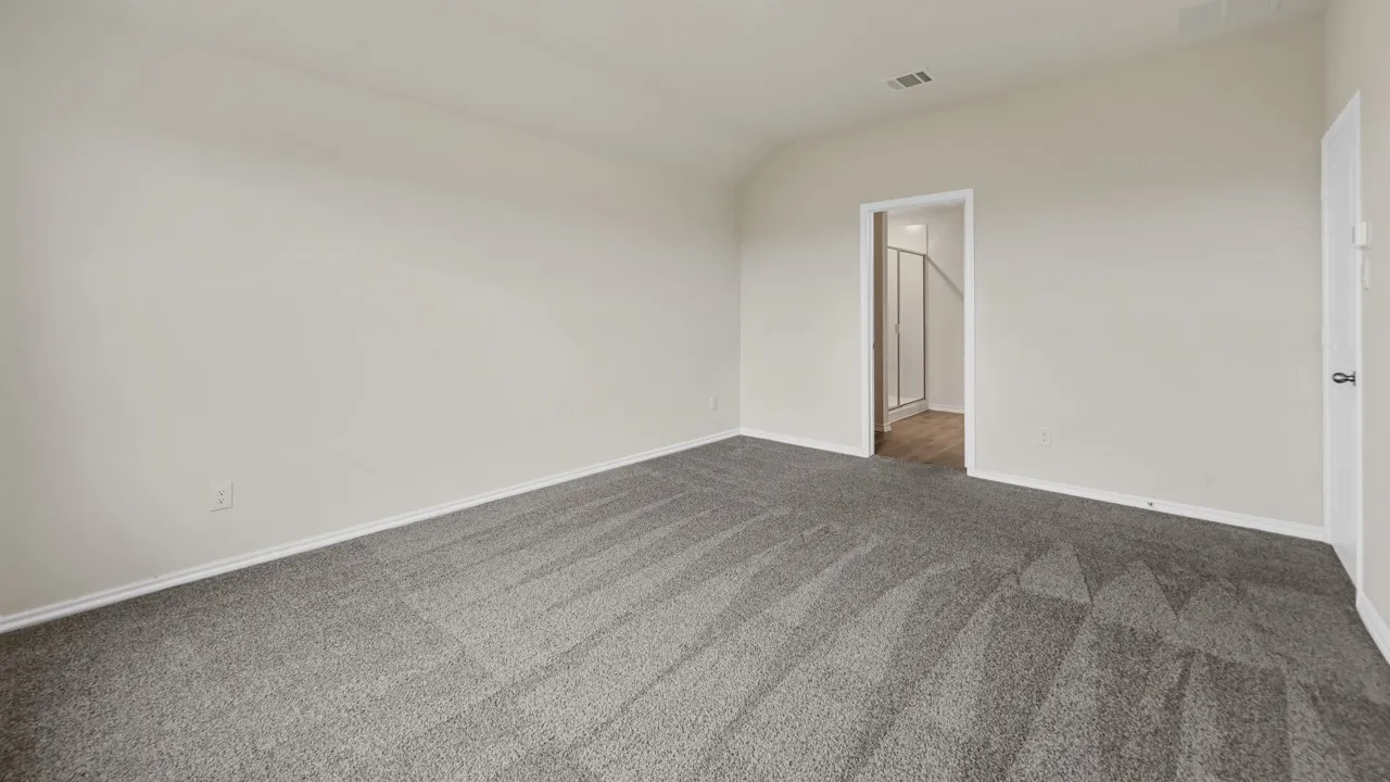 Spacious room with vaulted ceiling and gray patterned carpet