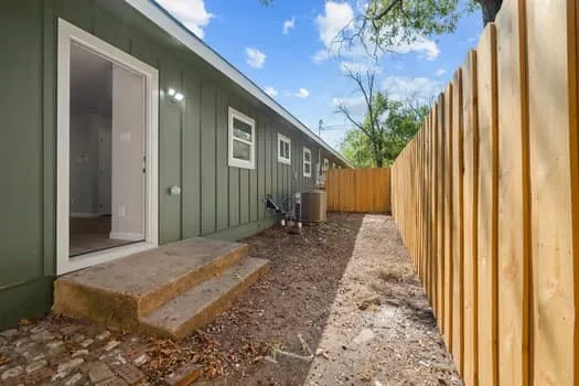 Exterior siding, concrete steps, and a newly installed wood fence