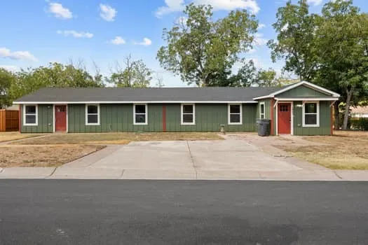 Single-story structure with green siding and white trim