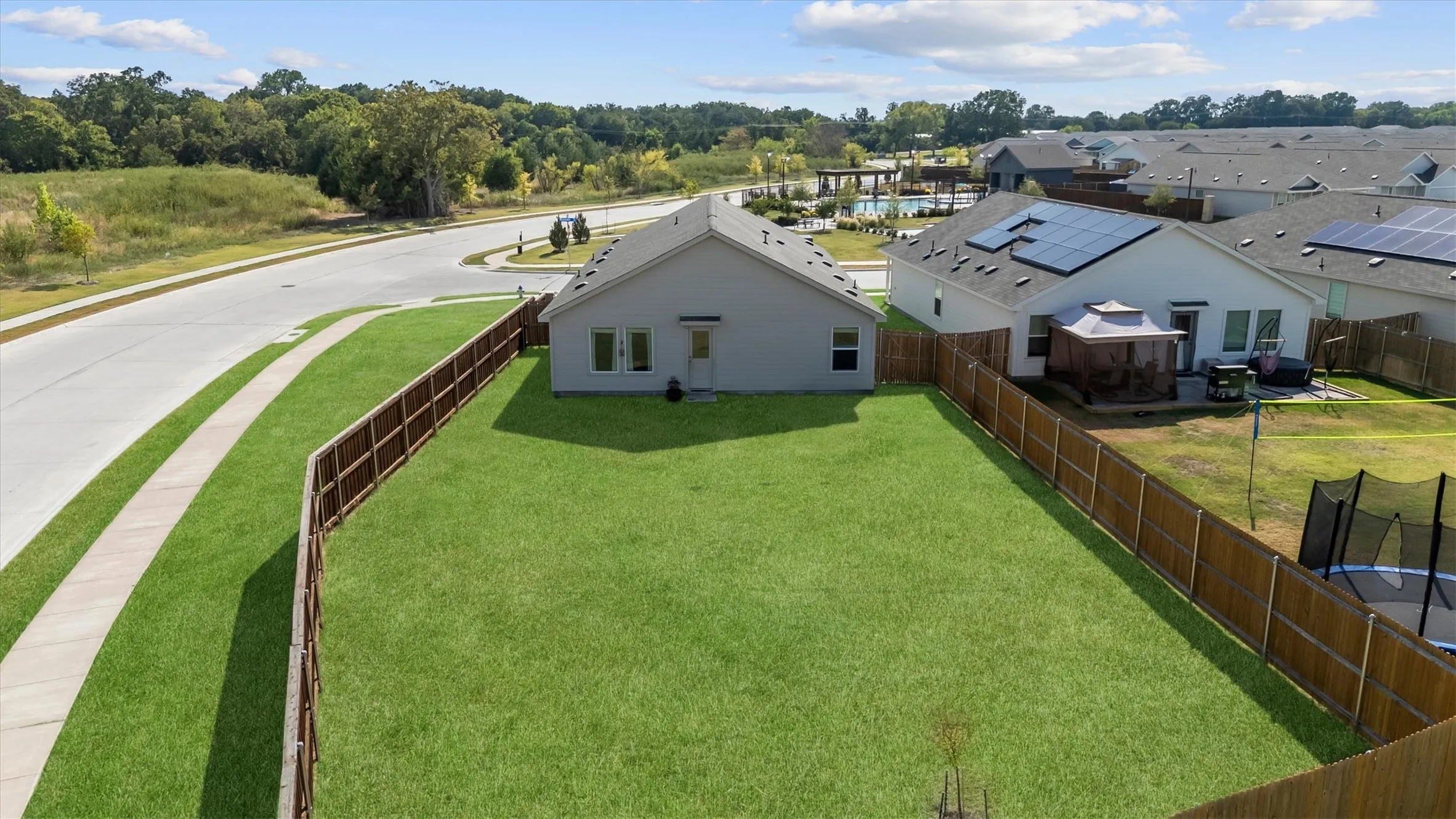 Large grassy backyard across the street from a greenbelt.