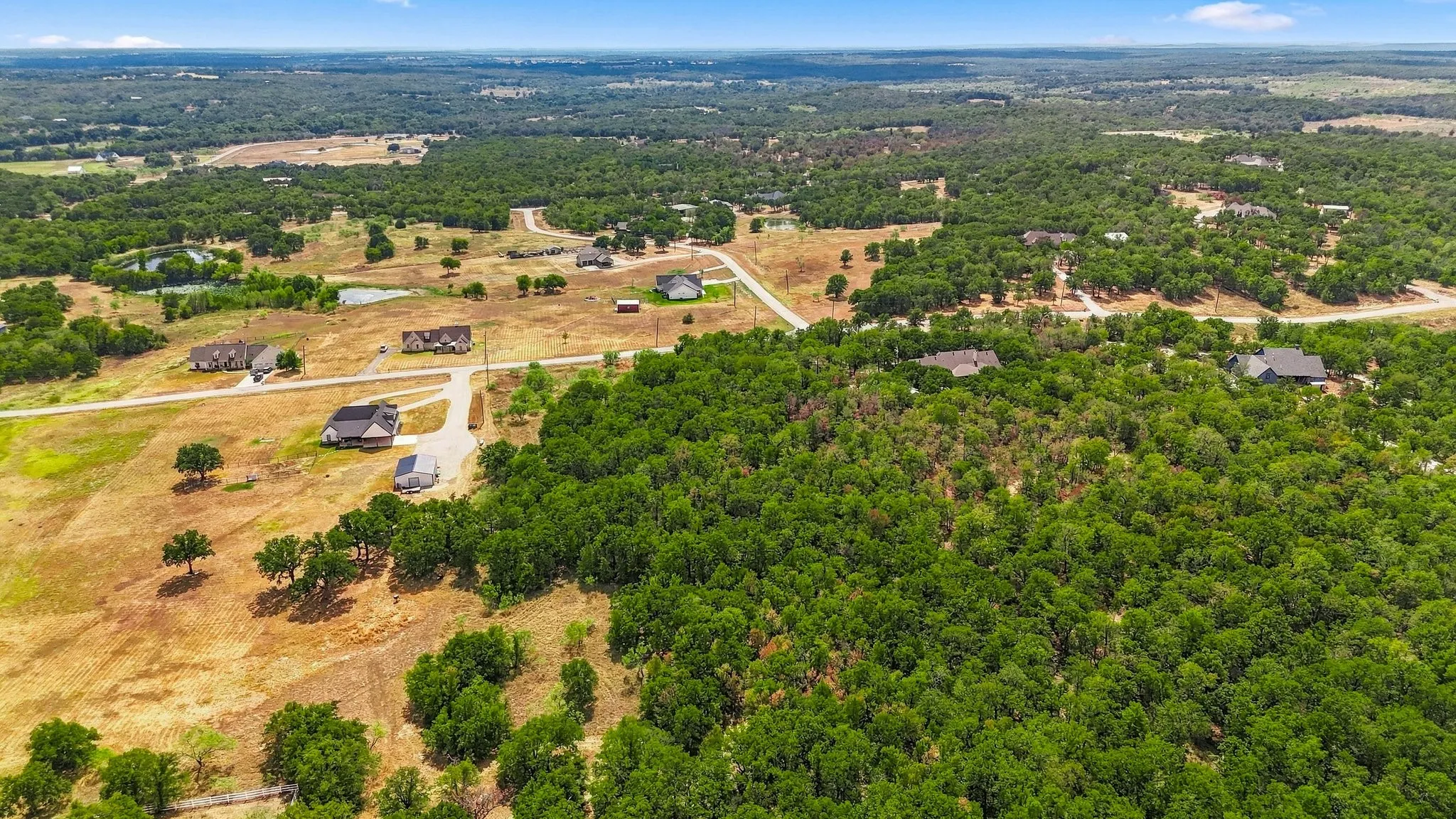 Expansive rural landscape featuring a mix of mature trees and open terrain