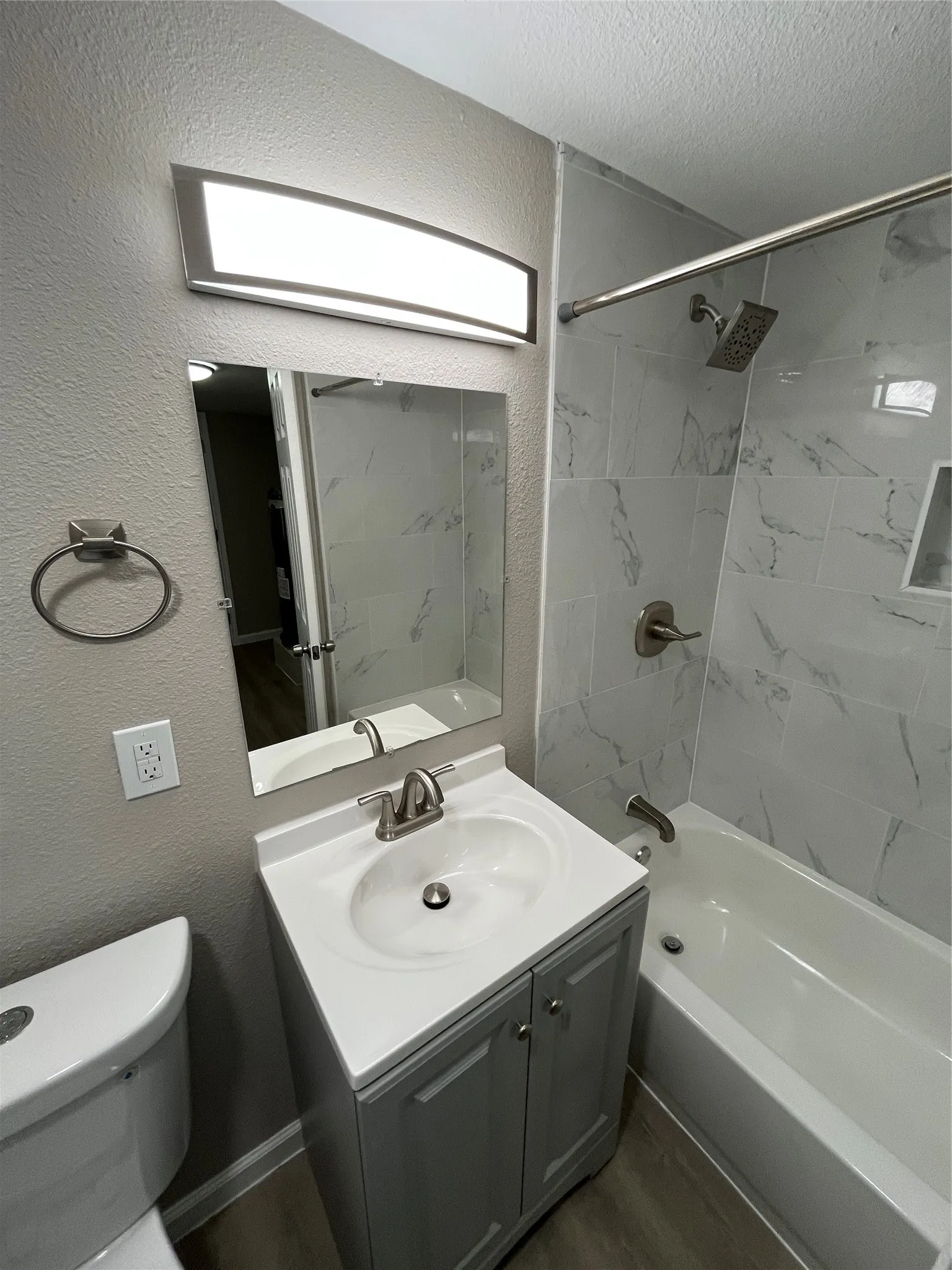 Vanity with an integrated sink, brushed nickel faucet, and a wall-mounted mirror